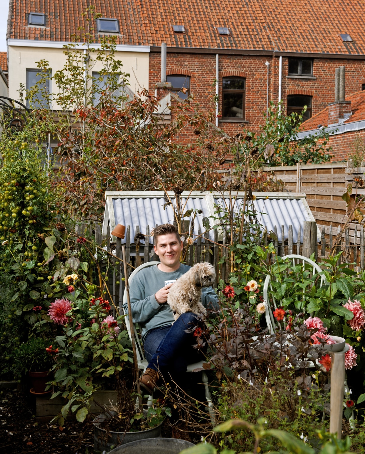 Angelo verfde twee kringloopstoelen in de kleur Vert de Terre van Farrow &amp; Ball. ‘Deze kleur bestaat niet in de natuur, waardoor omringend groen er sterk in uit komt.’ Erachter een van drie zelfgebouwde kippenrennen. vtwonen 2022-special TUIN 5 | binnenkijker 4 | styling Ilona Jongepier | fotografie Brenda van Leeuwen