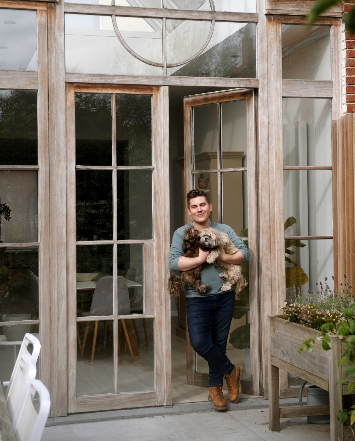 Angelo voor de pui van Afrormosia-hout, een Afrikaanse teaksoort. ‘De tuin is kleiner dan onze vorige tuin, maar we werden verliefd op deze raampartij. Vanaf de straat lijkt de woning een klein rijtjeshuis, maar binnen is het ongelooflijk licht en een stuk ruimer dan je zou denken.’ Herkomst stoelen onbekend. In de moestuinbak staan lavendel en eenjarige bloemen. vtwonen 2022-special TUIN 5 | binnenkijker 4 | styling Ilona Jongepier | fotografie Brenda van Leeuwen