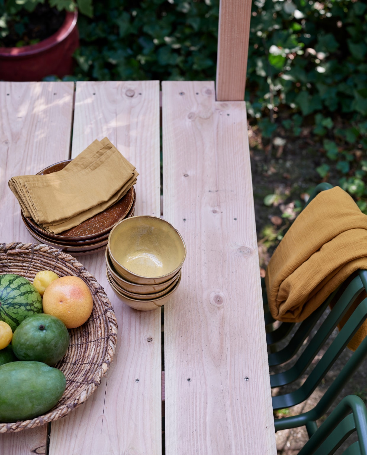 Tuinbank Luxembourg van Fermob, stoelen Palisade Chair van Hay (vtwonen.nl). Tafelkleed van okergele stof (patickkarteris.nl). Hoge vaas, diepe borden Glaze (kwantum.nl). Bamboe lantaarn, schaaltjes, schaal (intratuin.nl). Sisal schaal (hm.com). Linnen servetten (hm.com). vtwonen tuin special 5-2022 | diy large | styling Moniek Visser | fotografie Sven Benjamins