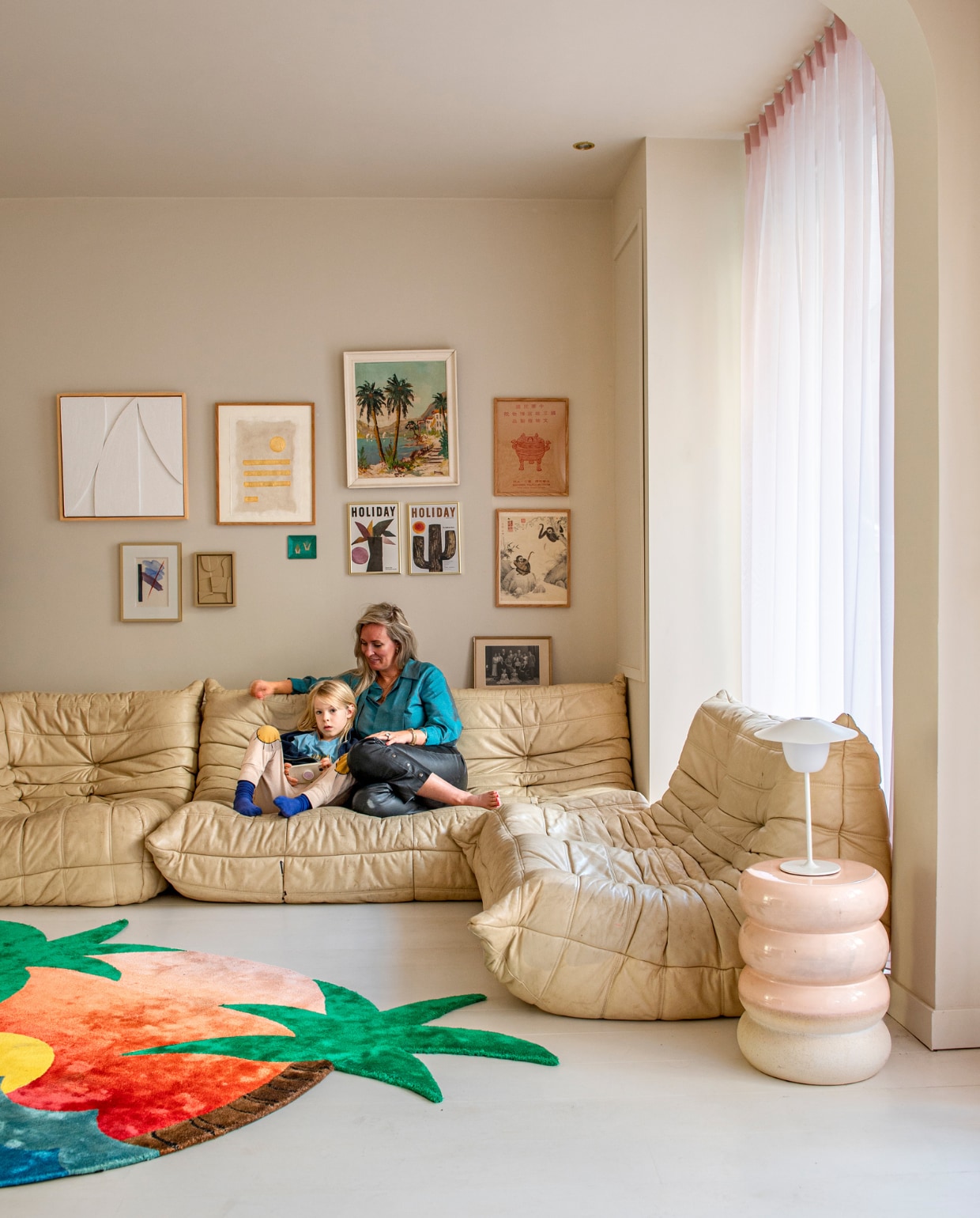 Bank Togo van Ligne Roset, bijzettafel Polspotten, tafellamp Ani van Blomus. Vloerkleed Sunset van Studio Vacay. Muur- en vloerverf Strong Garlic van Vestingh. Vitrage Veneta. Prints van onder andere Eau de Marie en Amy Maye Art. vtwonen 07-2023 | productie De Binnenkijkers | styling Jeske Weel | fotografie Caroline Coehorst