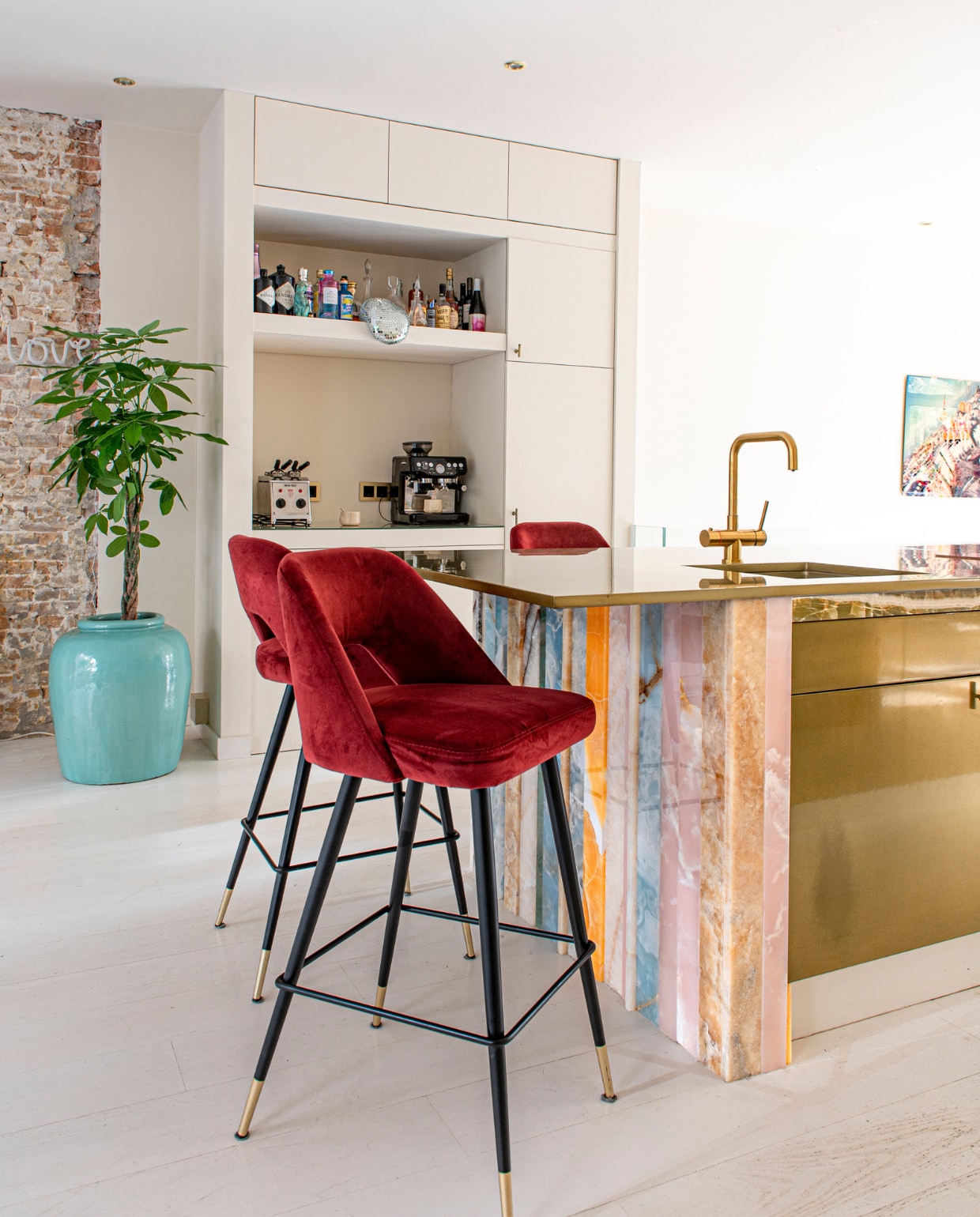 Turquoise bloempot Loods 5, plant Green Bubble. Keuken eigen ontwerp met onyx van Solid Nature, wandkast op maat gemaakt, barkrukken Eichholtz, kraan Selsiuz, tostiapparaat Milantoast. Muur- en vloerverf Strong Garlic van Vestingh. Overig  onbekend. vtwonen 07-2023 | productie De Binnenkijkers | styling Jeske Weel | fotografie Caroline Coehorst