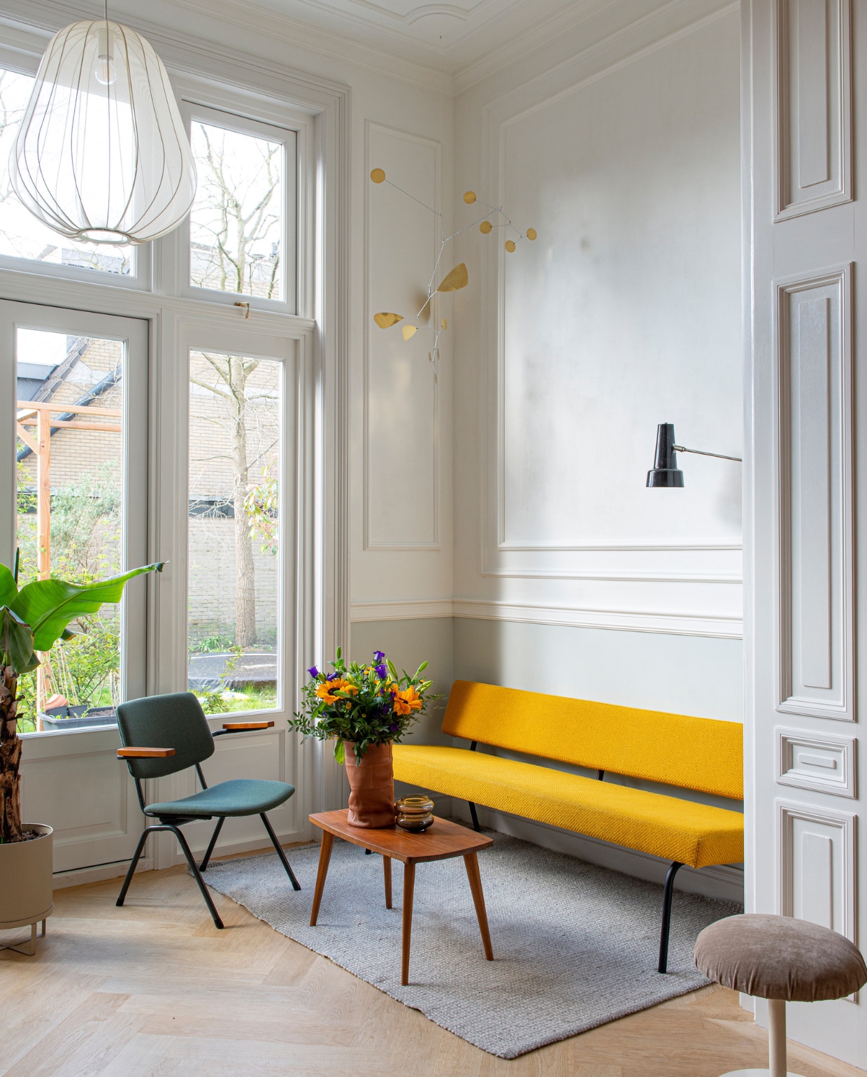 Verfkleur deurlijst Slaked Lime Mid en muur Pearl Color van Little Greene. Vloer Balkan Wood. Bank Fést. Tafel vintage. Fauteuil De Machinekamer. Bloempot Ferm Living. Hanglamp Bolia. Mobile Lappalainen. Hagoort-wandlamp Tijdperk. Hoes om vaas O My Bag. Vloerkleed H&amp;M Home. Kruk Meutt. vtwonen special binnenkijken 03-2023 | productie De Binnenkijkers | styling Jeske Weel | fotografie Caroline Coehorst