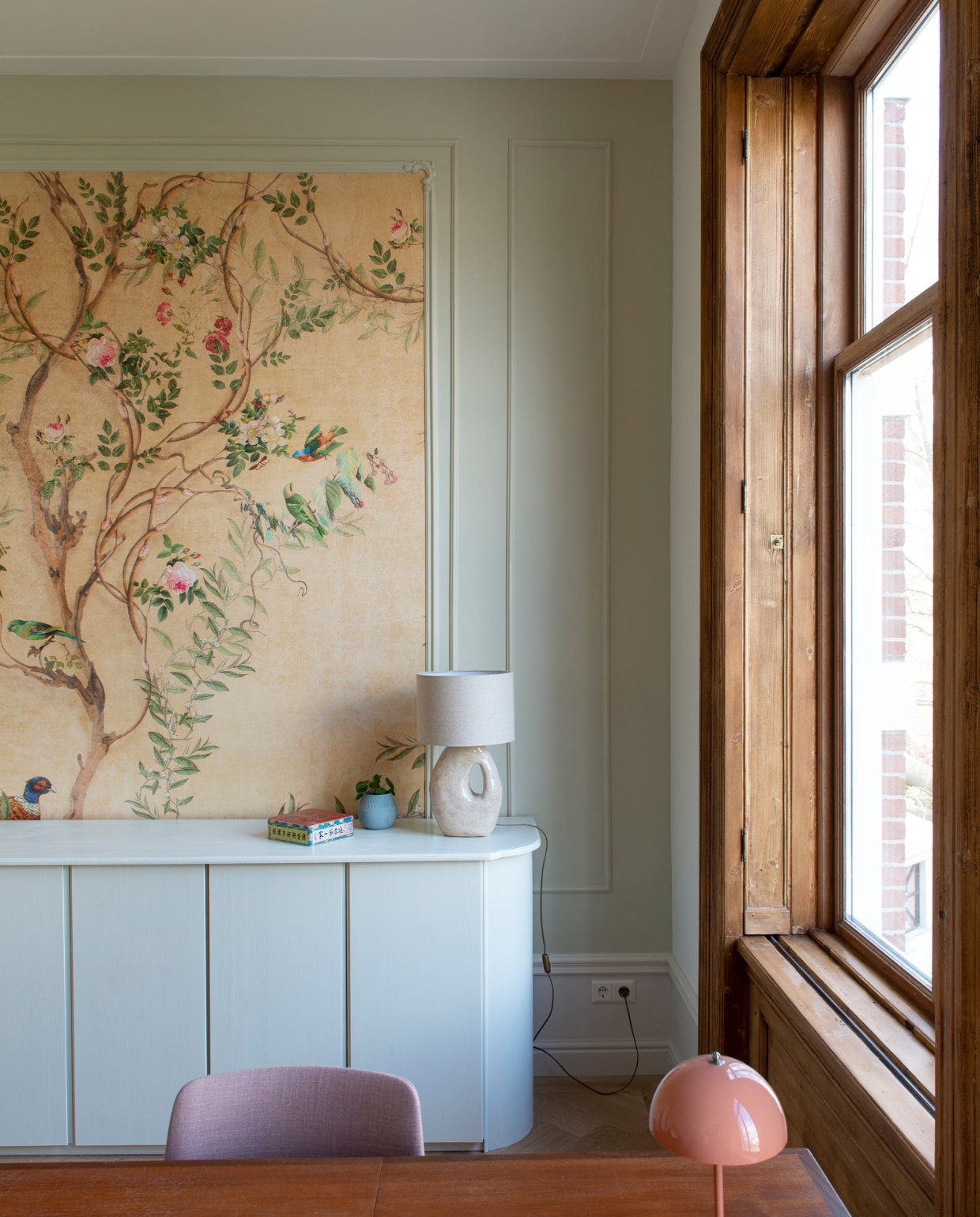 Verfkleur Green Stone van Little Greene. Behang Photowall.se. Kast zelf gebouwd en geschilderd in Willow II van Paint &amp; Paper Library. Lamp Atelier van Schaijck. Bloempot Studio Lenneke Wispelwey. Blik gekregen. Tafel vintage. Stoel De Machinekamer. Bureaulamp &amp;Tradition. vtwonen special binnenkijken 03-2023 | productie De Binnenkijkers | styling Jeske Weel | fotografie Caroline Coehorst