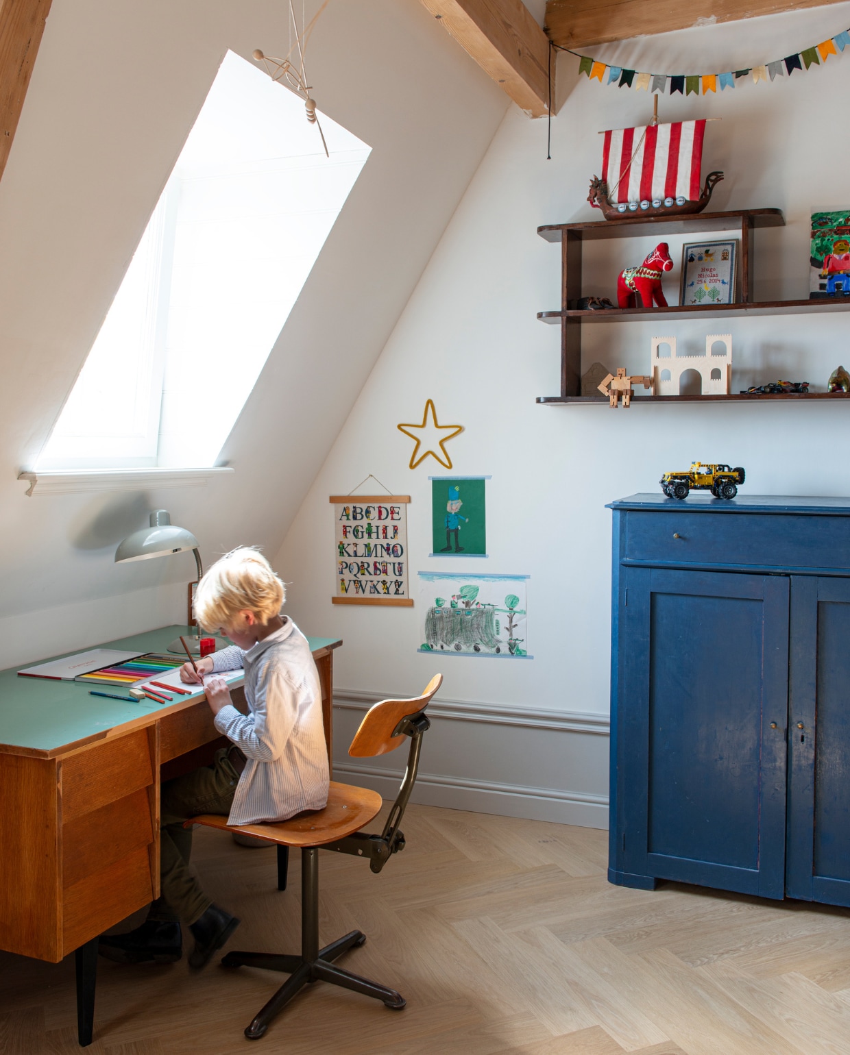Bureau en stoel Marktplaats. Bureaulamp Feestrijk. Alfabet en slinger zelfgemaakt. Plankenkast Firma Zoethout. Paardenknuffel uit Zweden. Kast Rosa Rugosa. vtwonen special binnenkijken 03-2023 | productie De Binnenkijkers | styling Jeske Weel  fotografie Caroline Coehorst