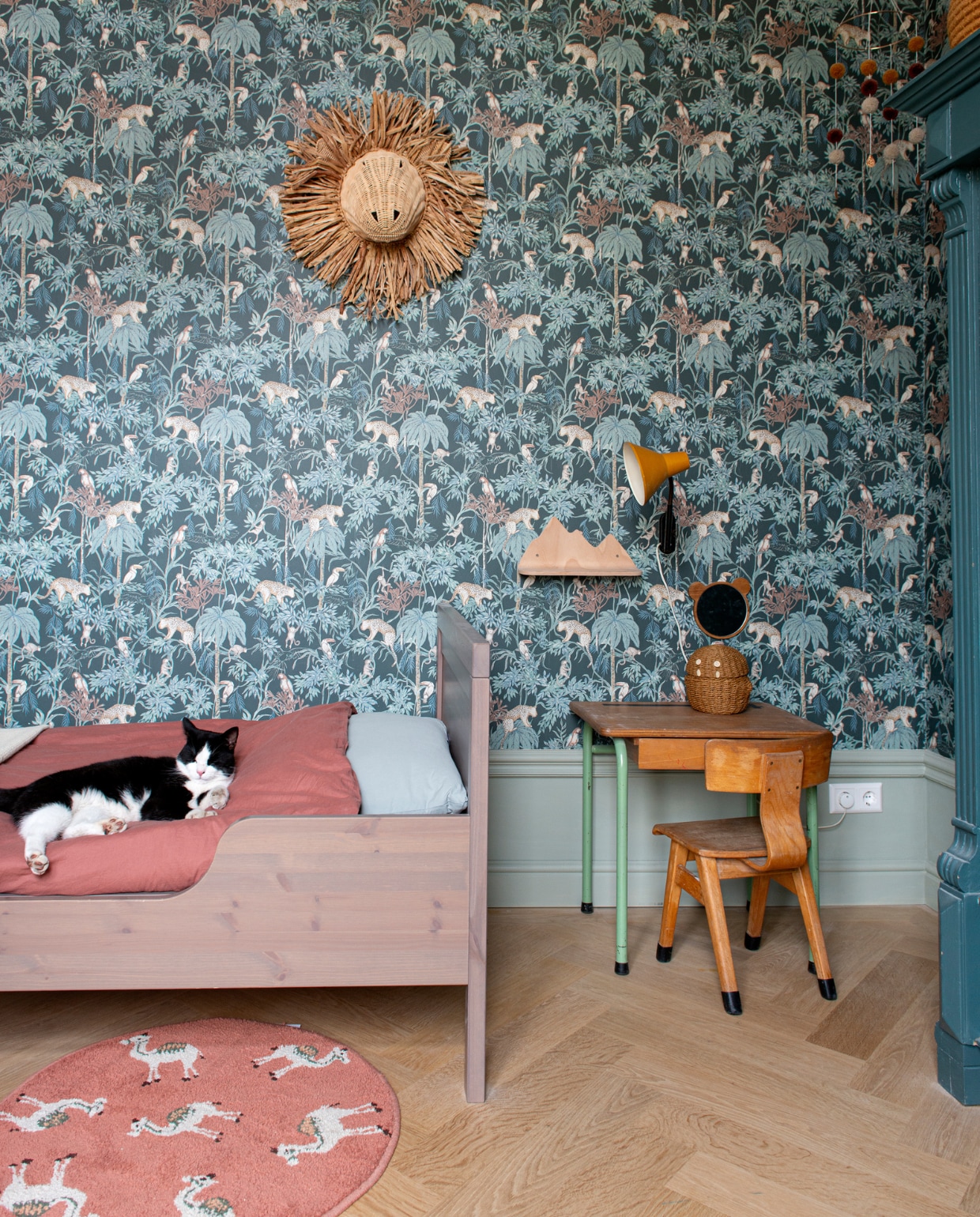 Behang Borastapeter. Verfkleur Normandy Grey van Little Greene. Bed Ikea. Dekbed Midnatt. Kussensloop Garbo&amp;Friends. Vloerkleed Casa. Leeuwenkop Firma Zoethout. Wolkenplank Pearls &amp; Swines. Bureau, stoel en lamp Marktplaats. Mand Zara Home. vtwonen special binnenkijken 03-2023 | productie De Binnenkijkers | styling Jeske Weel  fotografie Caroline Coehorst