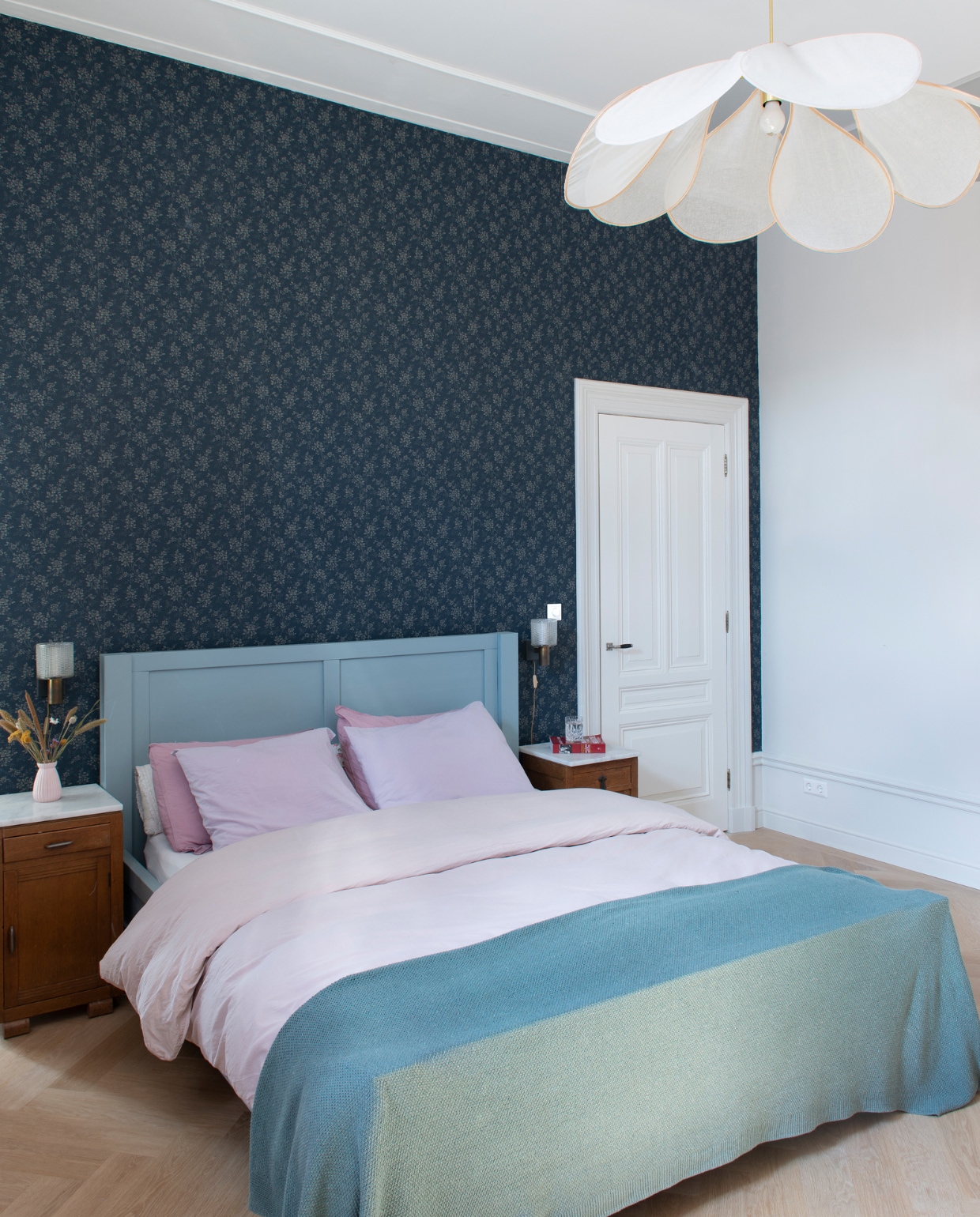 Behang Borastapeter. Verfkleur Slaked Lime Mid van Little Greene. Bed zelfgemaakt. Beddengoed Crisp en H&amp;M Home. Sprei By Mölle. Nachtkastjes, wandlampen en vaas Marktplaats. Hanglamp Georges Store. vtwonen special binnenkijken 03-2023 | productie De Binnenkijkers | styling Jeske Weel | fotografie Caroline Coehorst