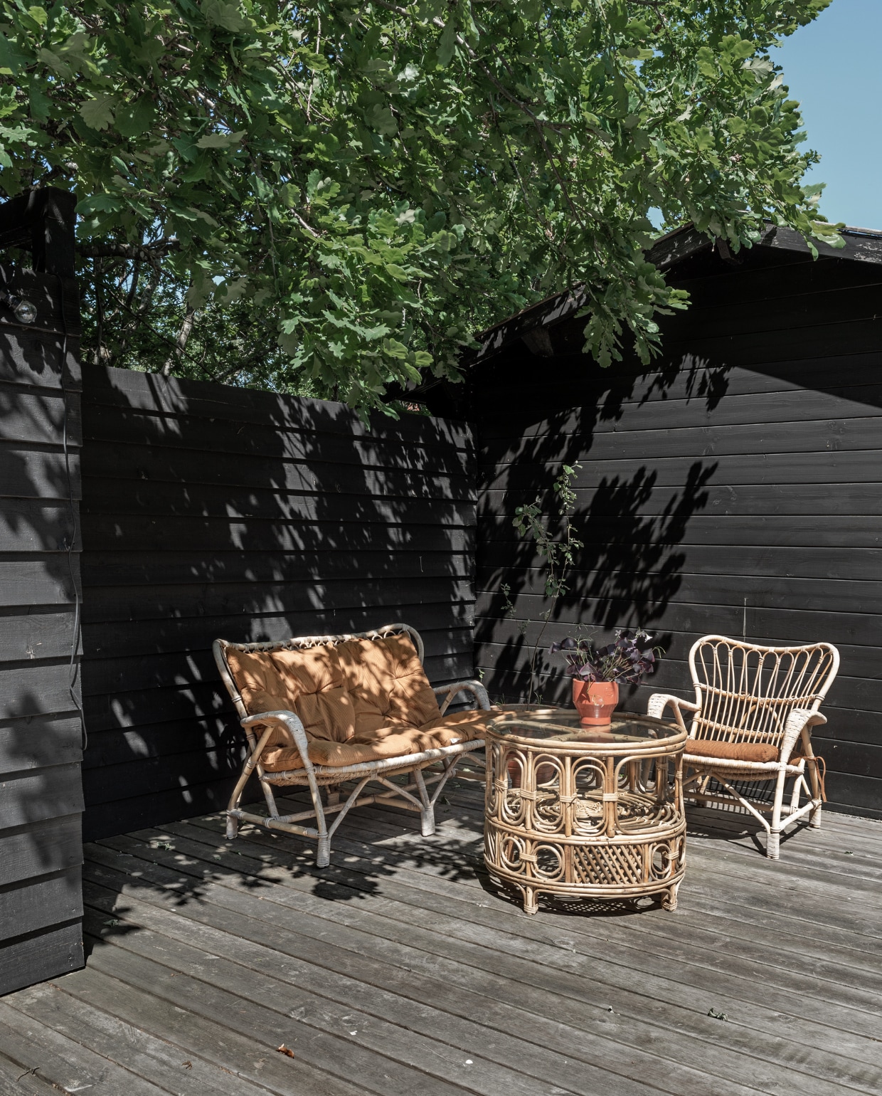 Rotan bank, fauteuil en salontafel rommelmarkt. Kussens Madam Stoltz. Plantenpot Skagerak. vtwonen special binnenkijken 06-2022 | productie Living Inside | fotografie Peter Kragballe