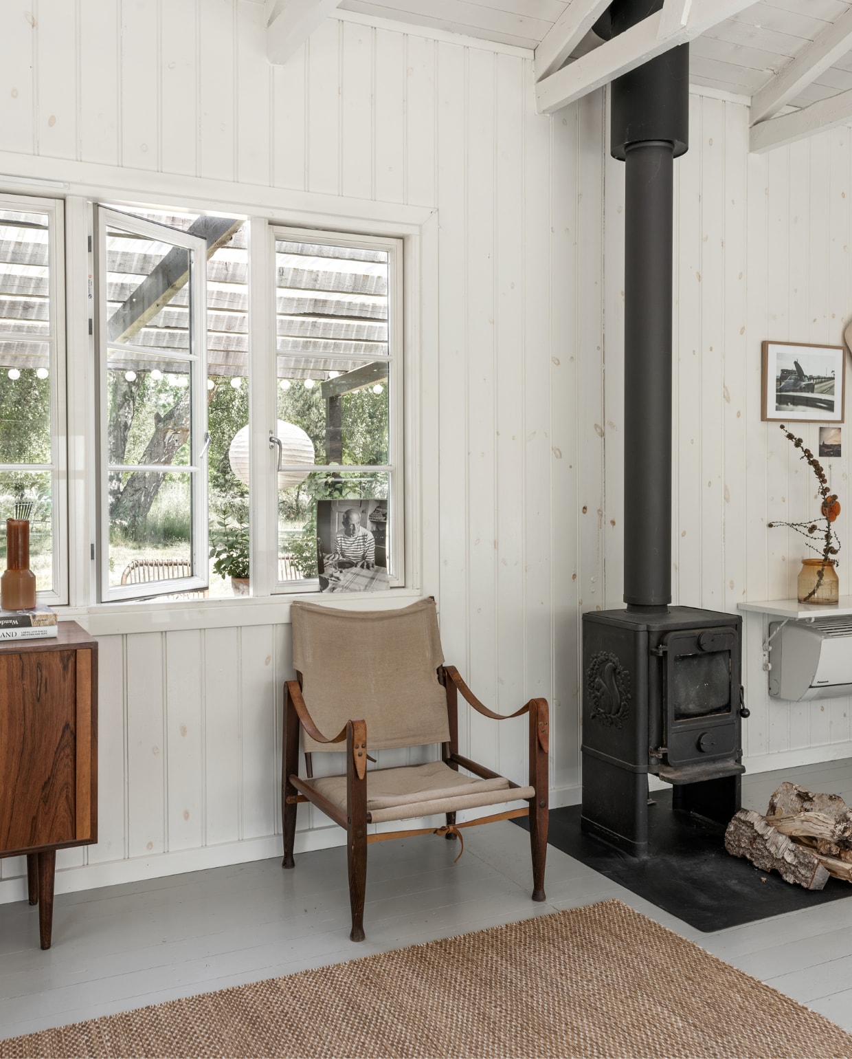 Safaristoel van Kaare Klint is een erfstuk van Rikke,s ouders. Houtkachel Mårsø. Vloerkleed Hay. vtwonen special binnenkijken 06-2022 | productie Living Inside | fotografie Peter Kragballe