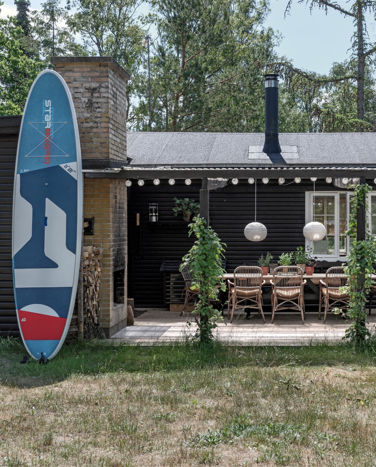 Paddle board Starboard. Rotan stoelen rommelmarkt. Bollamp Rabens Saloner. vtwonen special binnenkijken 06-2022 | productie Living Inside | fotografie Peter Kragballe