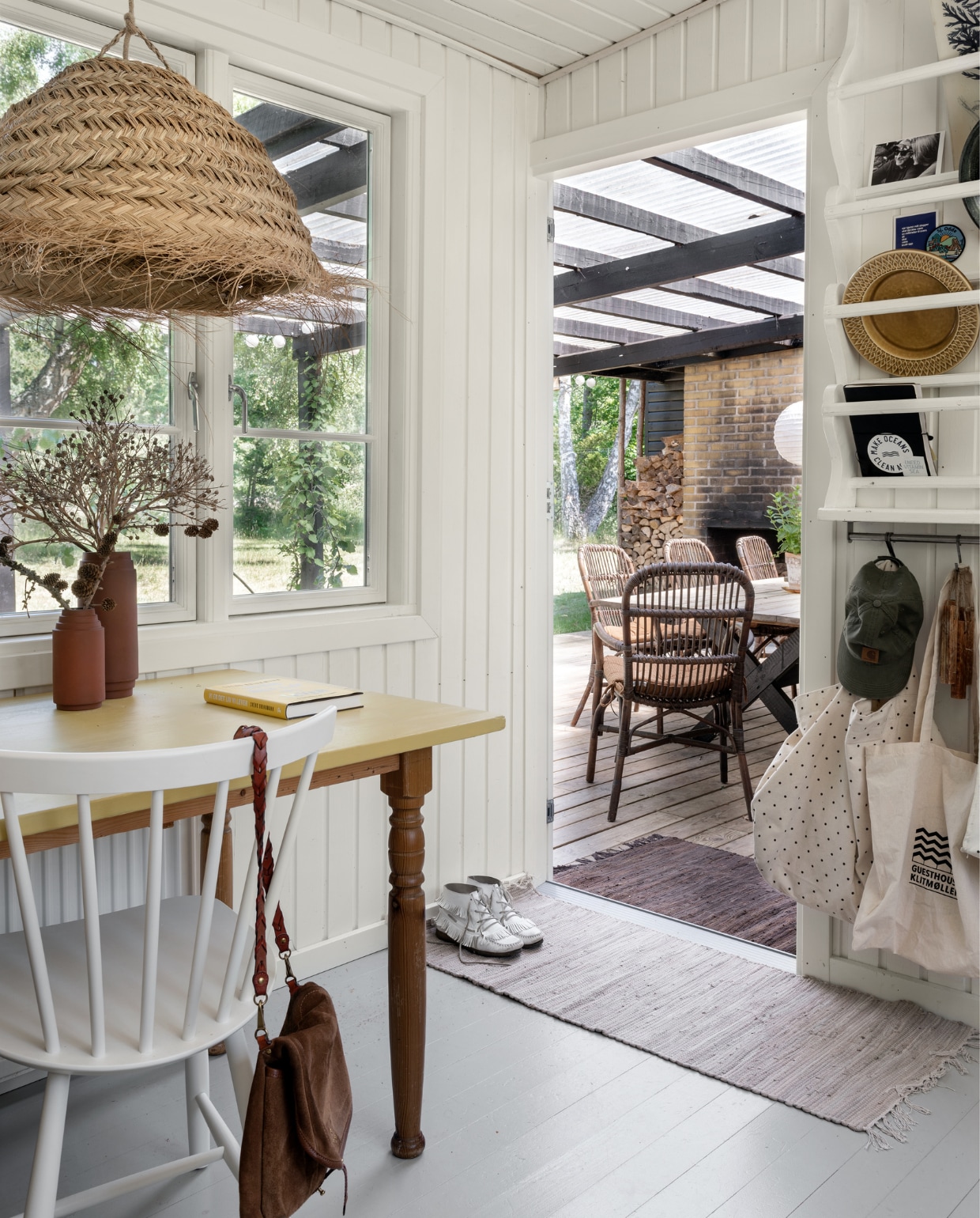 De tafel is nog van Rikke,s ouders geweest, waarvan Rikke het blad geel schilderde. Vaasjes rommelmarkt. Stoelen J46 FDB Møbler. Schoudertas Jerome Dreyfuss. Het witgeverfde bordenrek is zelfgemaakt, met daarin o.a. kaarten, vintage keramiek en tassen en een waterfles van Moshi Moshi Mind. Strolamp Madam Stoltz. Kleden Søstrene Grene. vtwonen special binnenkijken 06-2022 | productie Living Inside | fotografie Peter Kragballe