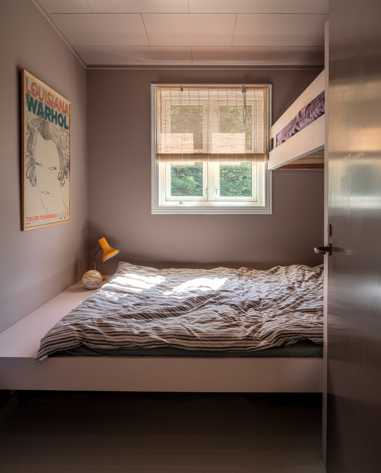 Logeerbed met hoogslaper op maat gemaakt. Beddengoed Moshi Moshi Mind. Rieten rolgordijnen Aziatische winkel. Lamp rommelmarkt. Andy Warhol-expositieposter vintage. Glazen bollamp Hay. vtwonen special binnenkijken 06-2022 | productie Living Inside | fotografie Peter Kragballe