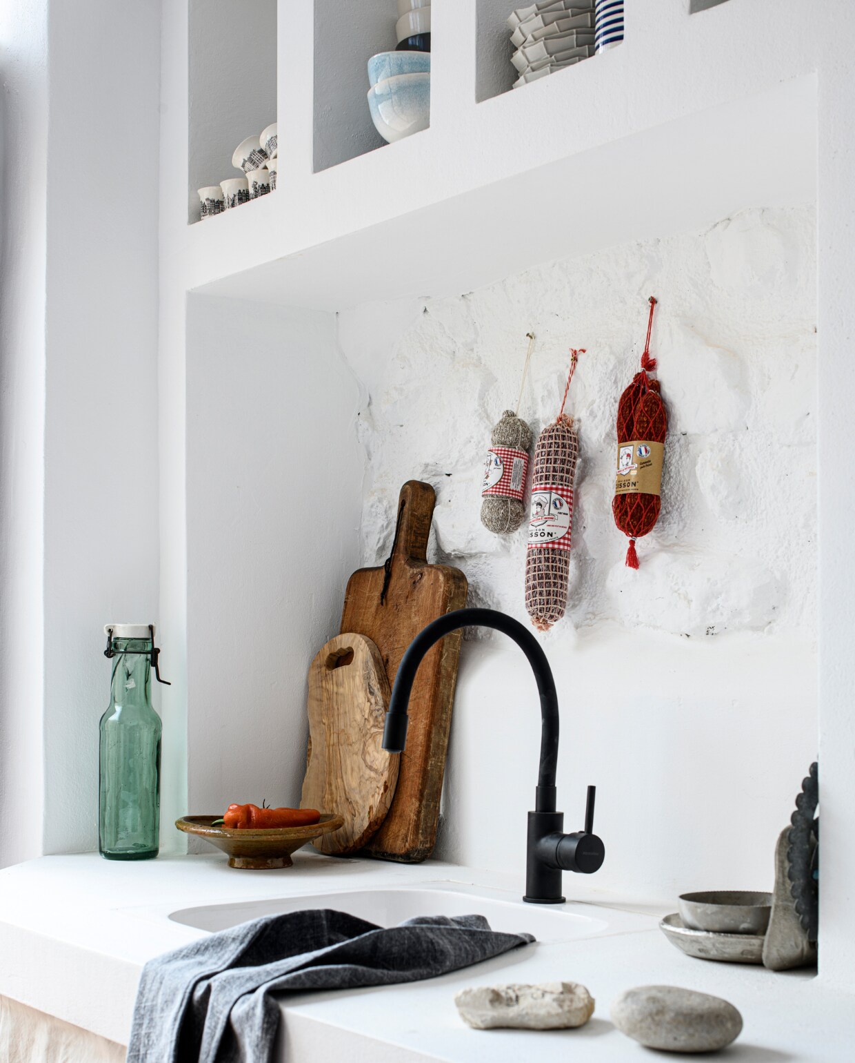 Kommen Westwing. Grijze borden van Serax en kraan Bva Auctions, gebreide worsten Merci. Overig onbekend. vtwonen 07-2023 | productie InsideHomePage | styling Inge van Lieshout | fotografie Louis Lemaire
