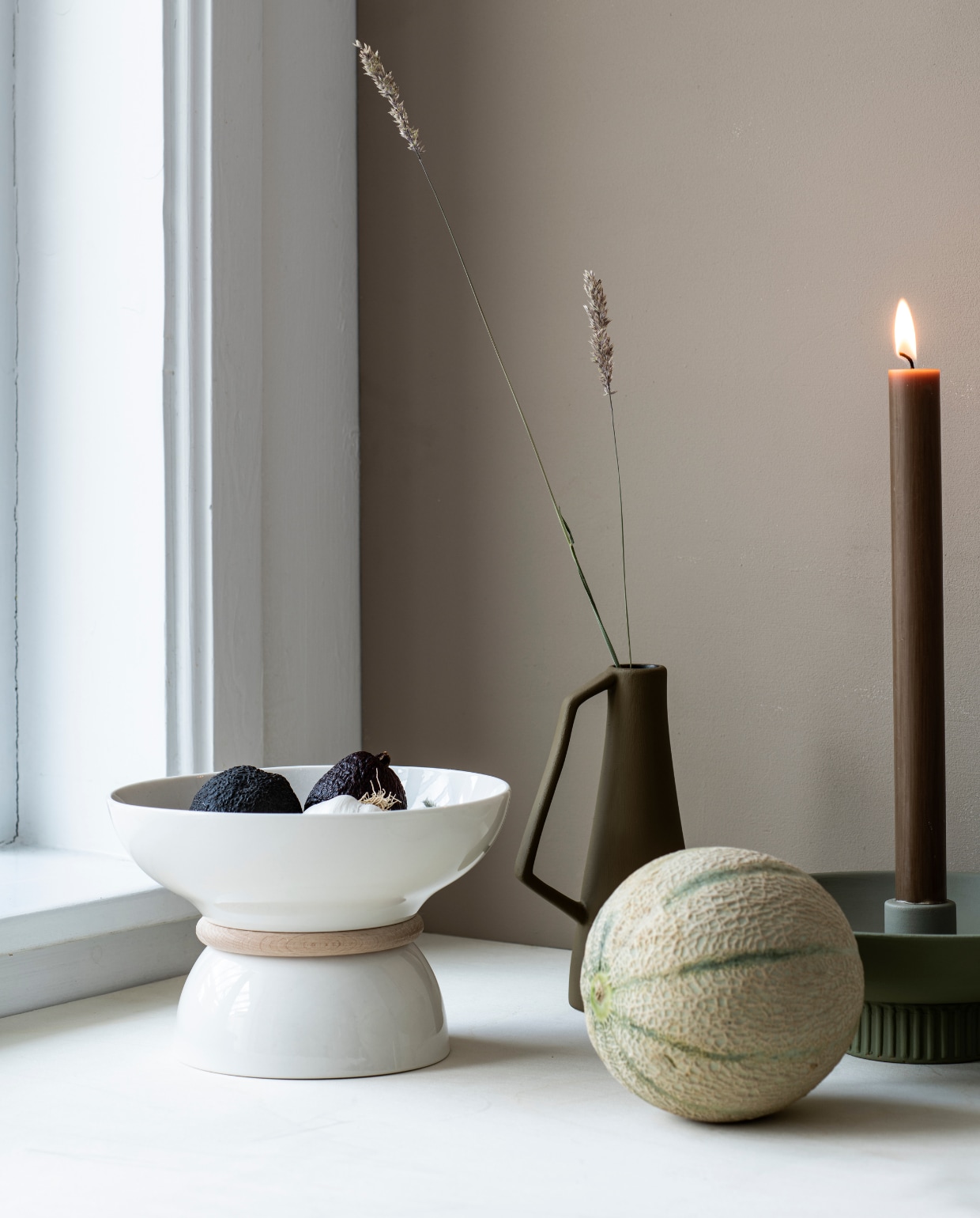 Kleur op de wand Rolling Fog - dark 160 (littlegreene.nl). Kandelaar geschilderd in Flexa Woudgroen € 8,99, karaf/vaas geschilderd in Little Greene Light Bronze Green € 12,99 (karwei.nl). Kaars kleur Tabac € 1,95 (zaanschfaamwebshop.nl). vtwonen special DIY 11-2021 | styling Myla Griese | fotografie Louis Lemaire