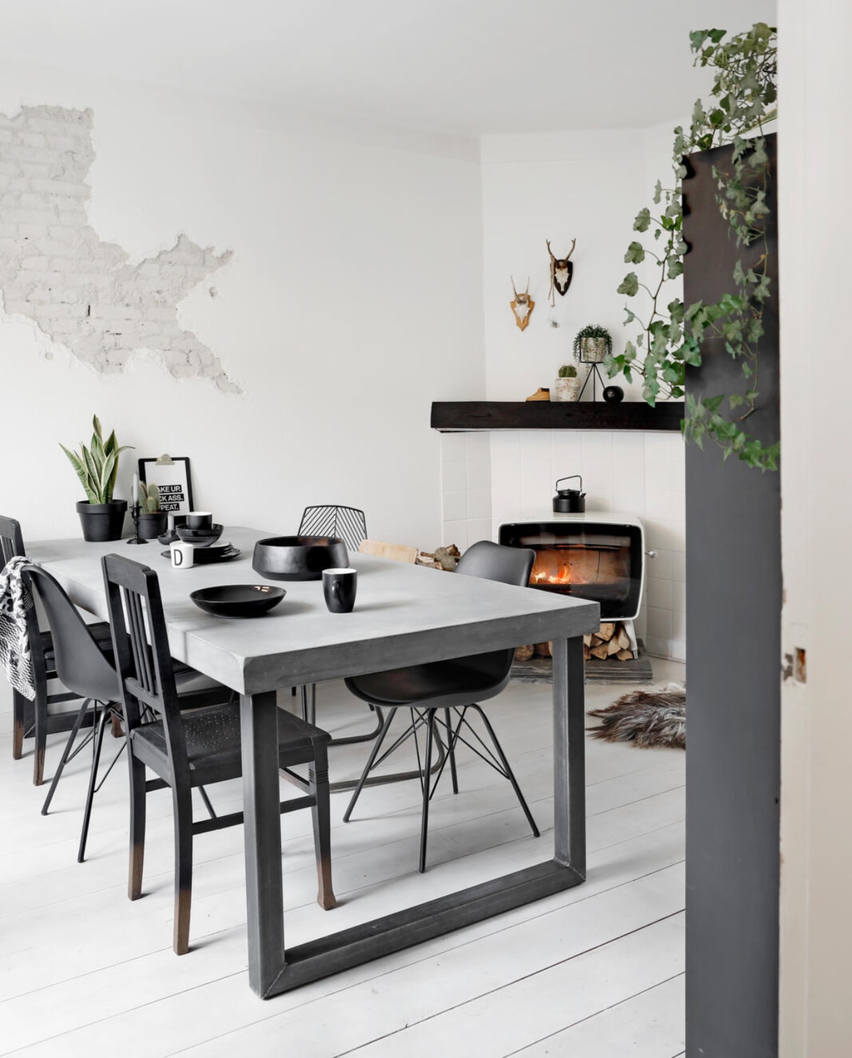 De tafel met betonlook is gemaakt door een vriend met een eigen bedrijf (meubel-idee.nl). Kuipstoeltjes Jysk, houten stoelen kringloop, draadstoel www.vintagelab15.com. De schaal van Trendhopper is zwart gespoten. Servies Design Letters. Haard Dovre. Geweien online gevonden. Plantenstandaard Men at work. De houten balk heeft Anne Marie zwart gemaakt. vtwonen 09-2017 | Fotografie Peggy Janssen