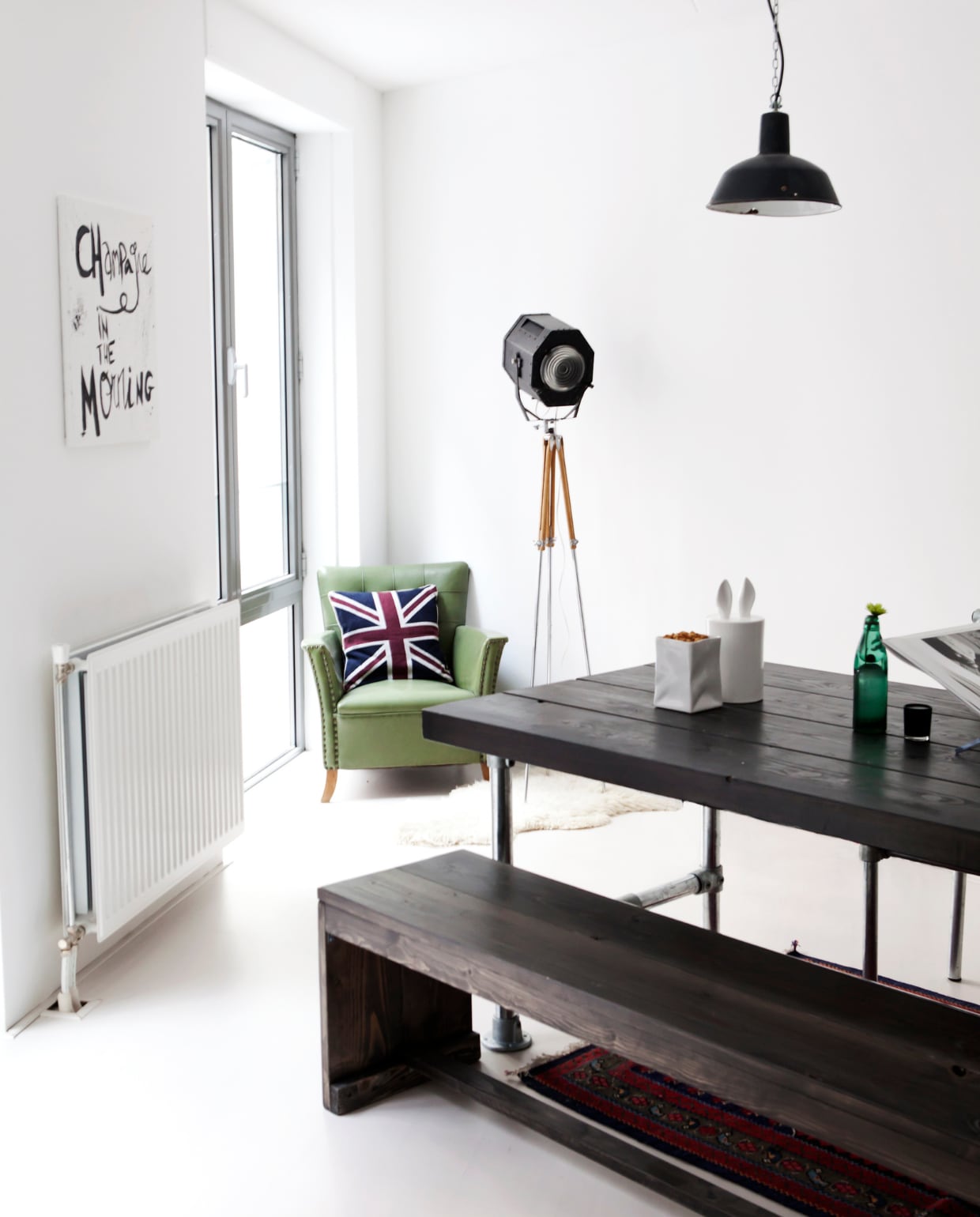 De tafel werd op maat gemaakt van steigerhout en buizen, net als de twee stoelen die Anna zelf ontwierp. De staande lamp vond Anna op Marktplaats, net als de industriële hanglampen boven de tafel. Op de boekenstandaard op tafel ligt een fotoboek van Helmut Newton. Onder de tafel een Perzisch tapijt dat Anna’s moeder voor haar meenam uit Iran. vtwonen 05-2014 | Fotografie Barbara de Hosson