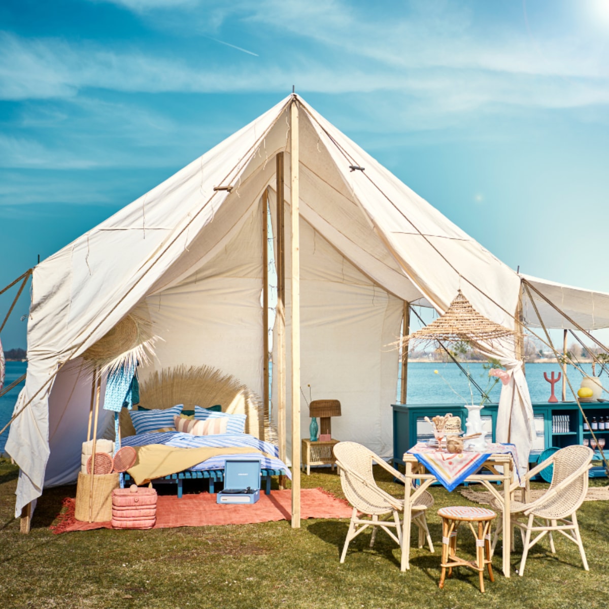 Tent met houten frame, blauwe keuken en daybed van Combitex, prijs op aanvraag (com-anders.nl). Ligstoel Zeya links, rotan kapstok met mand Sio, rotan lamp Atum op nachtkast, yogamat Yin opgerold in kapstok, kleed keuken, 200x75 cm, grote en kleine afdekmanden en grote witte pot, prijs op aanvraag (nordal.dk). Rood-oranje vintage hennep tapijt, 248x 268 cm, kruk Malawi naast bed, bamboe en rotan, hoofdeinde van palmbladeren, dadelpalmtak hanglamp, blauw-wit gestreept linnen dekbedovertrek large, geel dekbedovertrek Straw, bamboe trolley, hoed van palmblad uit Marokko, blauwe fruitschaal tegen keuken (couleurlocale.eu). Tafelkleed en vlag, 90x90 cm, prijs op aanvraag (hm.com). Mand met olijfboom, 53x62 cm (Øxh), fairtrade blauwe jas (weldaad.com). Handgemaakte rotan kruk (ha50.nl). Kleine houten lepel op tafel, kleine houten bak op tafel, kleine houten borden, grote lepel achter op tafel, mand aan tent met 3 etages, houten tafel, houten stoelen, per stuk, snijplank, roze-wit gestreept kussen (householdhardware.nl). Roze mand (dekringloper.nl). Bord citroen in keuken, roze wijnglas, per stuk (maisonnl.com). Platenspeler, beige vaas in keuken, roze kandelaar, oranje-wit geruit servet, set van 2 (sissy-boy.com). Witte vaas Billy van Serax, 31 cm (h), blauwe karaf Fish &amp; Fish van Serax, 1 liter, vuurkorf Modern Ronda van Barbecook, taartplateau Inku van Serax, 24 cm (Ø), fruitmand (vtwonen.nl/shop). Blauw-wit gestreepte box in keuken van Hay, radio van Lexon, roze tennisset van Liewood (bijenkorf.nl). Geruit kussen op ligbed, 60x40 cm (letoile.store). Takken, prijs op aanvraag (waterdrinker.nl). Overig privébezit. vtwonen 07-2023 | styling Liza Wassenaar | fotografie Sjoerd Eickmans