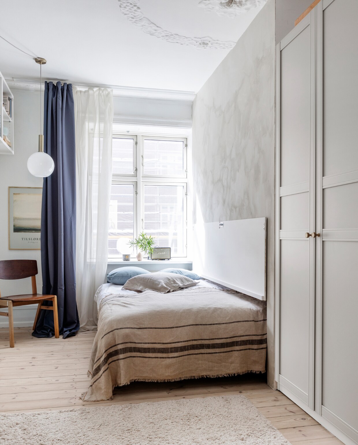 Verfkleur Washed Linen van Jotun. Gordijnen en tapijt Ellos. Stoel tweedehands. Poster Annette Højgaard. Hanglamp Ferm Living. Bed op maat gemaakt. Beddengoed Menu. Sprei H&amp;M Home. Vaas Tina Marie Cph. Radio Marshall. Overig onbekend. vtwonen special binnenkijken 03-2023 | productie Living Inside | styling Rikke Graff Juel | fotografie Christina Kayser Onsgaard