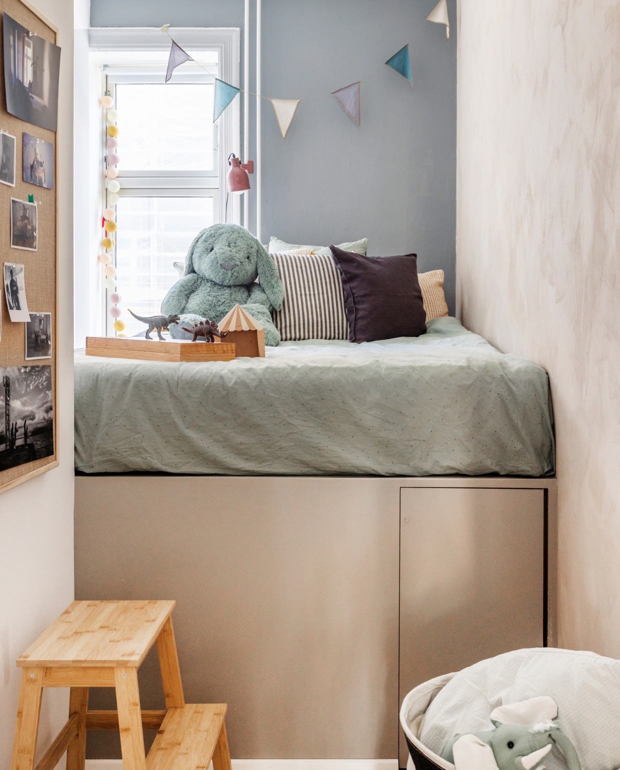 Verfkleuren Devine en Warm Grey van Jotun. Bed op maat gemaakt en geverfd in Warm Grey van Jotun. Beddengoed Jysk. Kussens H&amp;M Home. Vlaggen Numero 74. Kruk Ikea. Mand House Doctor. Overig onbekend. vtwonen special binnenkijken 03-2023 | productie Living Inside | styling Rikke Graff Juel | fotografie Christina Kayser Onsgaard