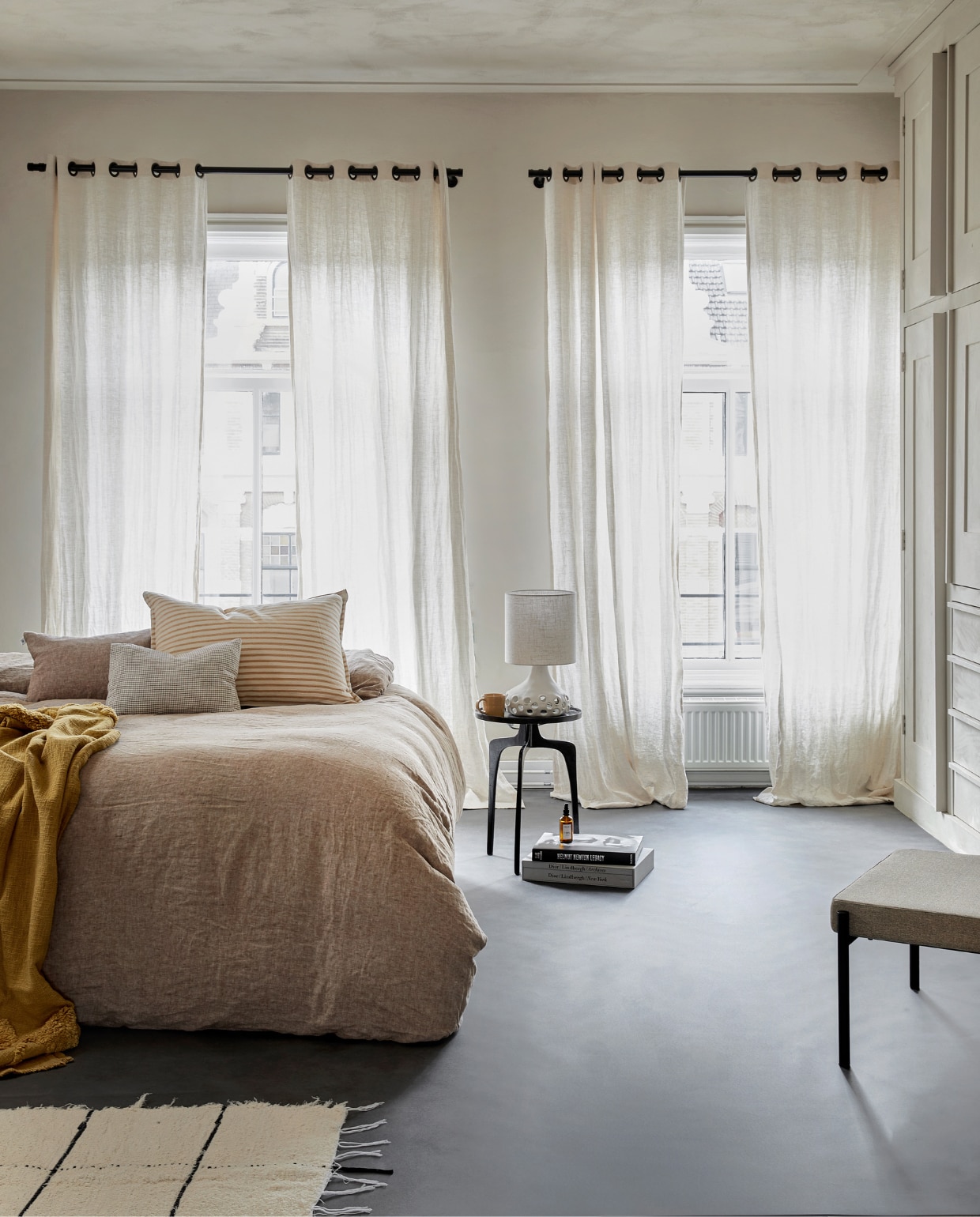 Novilon vloer in Basalt, per m² € 36,75 (excl. installatie). M.m.v. bymolle.com (beddengoed), letoile.store (kussens op bed Hazel, vloerkleed, mok), serax.com (lamp Oya, footstool Curve), vtwonen.nl/shop (plaid Yolk van Urban Nature Culture), justanothershop.nl (bijzettafel). vtwonen 07-2023 | productie Tanja Saarberg | styling Marlies Does | fotografie Peggy Janssen | assistentie Lisa Weel