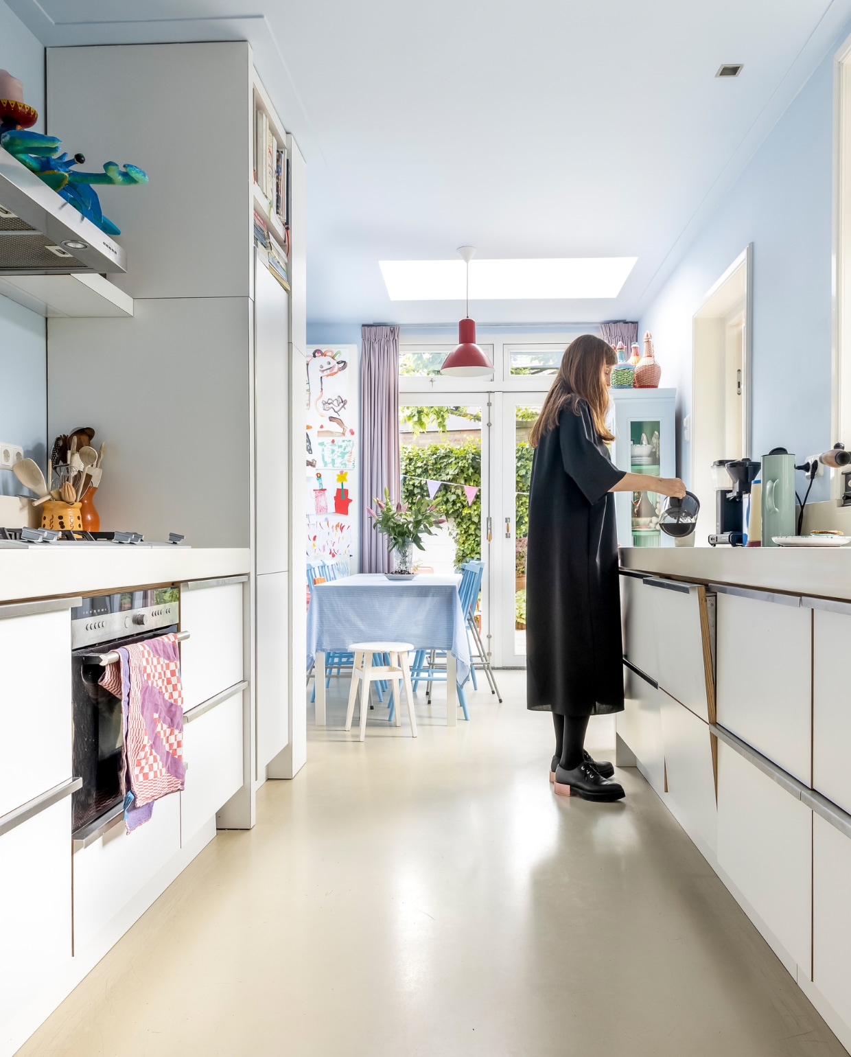 Muur- en plafondverf S2.08.79 van Sikkens, keuken ontworpen door vorige bewoners en gemaakt door Kees van de Ven, theedoek Viktor&amp;Rolf voor TextielMuseum, gordijnen Hema. Op afzuigkap kreeft van papier-maché en kast Markplaats, kast geschilderd in de kleur van de muur. Koffiezetapparaat Moccamaster, thermoskan Stelton, tekeningen van de kinderen. Tafel Ikea, tafelkleed zelfgemaakt. Overig vintage. vtwonen 07-2023 | fotografie Henny van Belkom