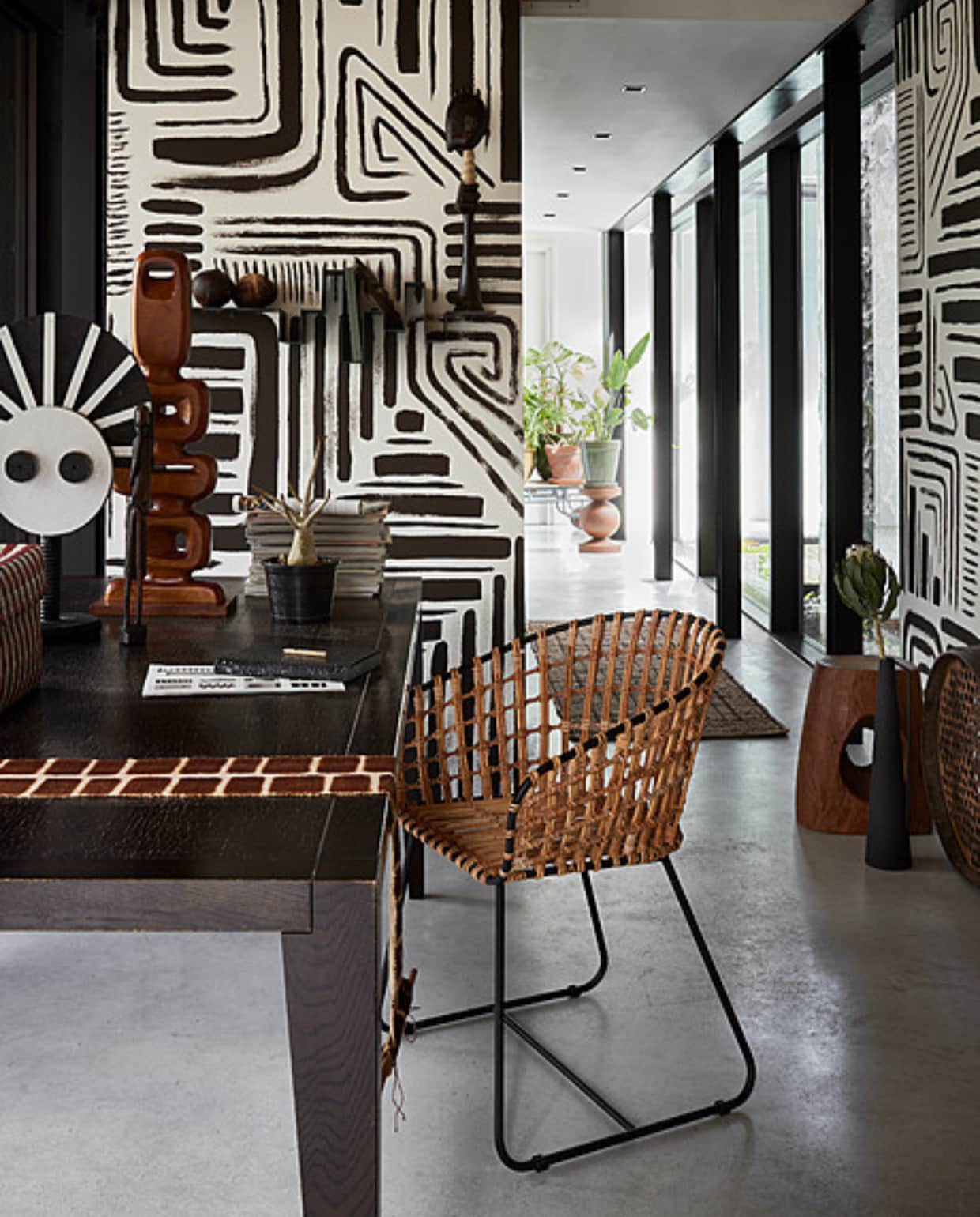 Muurverf wandschildering Charcoal van Lab Paint (vestingh.nl). Tweedehands tafel, 220x100x75 cm (lxbxh), tweedehands object op voet, 55 cm (h), tweedehands Afrikaans beeld, tweedehands kokosnoten op plank, tweedehands hoog beeld op plank, 50 cm (h) (dekringloper.nl). Teakhouten object, 25x9x71 cm (bxdxh) (hkliving.nl). Opbergdoos Maxim, gerecyclede plastic strips (hay.nl). Wandhanger Totem Process van Aaaa, katoen geverfd met modder en kruiden (sukha.nl). Rotan stoel Tokyo, metaal, rotan en polyester, 53x54x79 cm (bxdxh), houten kruk Devil’s Eye, 30x25x45 cm (bxdxh), houten kruk Ball, 35x40 cm (Øxh), zwarte gepoedercoat metalen vaas Roman, 11,5x52 cm (Øxh), set van 4 (polspotten.com). Vintage zeef (vandijkenko.nl). Wandplank Storylines van Studio Frederik Roijé, 90x30x28 cm (lxdxh) (vtwonen.nl/shop). Planten en potten, prijs op aanvraag (bydennis.nl). vtwonen 08-2023 | styling Fietje Bruijn | fotografie Alexander van Berge