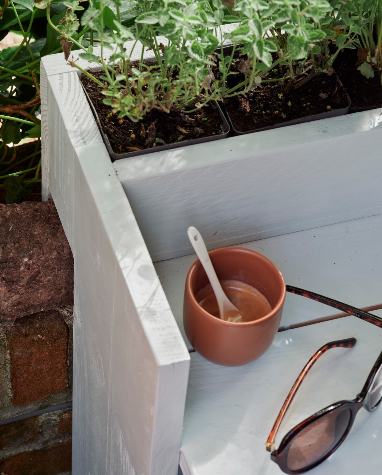 Zeegroene karaf, terra mokken Alva, klein, per stuk, linnen terra plaid (loods5.nl). Groene plantenpot (dille-kamille.nl). Groene emmer, plantenhanger, terra plantenpot Diego (intratuin.nl). Espadrilles en zonnebril privébezit. vtwonen 06-2023 | Tuin special 6 | Styling Moniek Visser | Fotografie Sven Benjamins