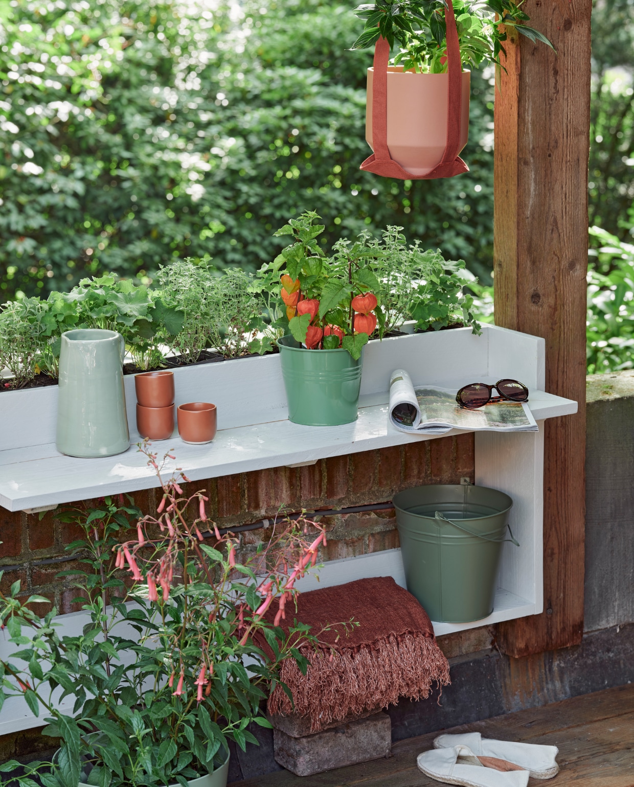 Zeegroene karaf, terra mokken Alva, klein, per stuk, linnen terra plaid (loods5.nl). Groene plantenpot (dille-kamille.nl). Groene emmer, plantenhanger, terra plantenpot Diego (intratuin.nl). Espadrilles en zonnebril privébezit.