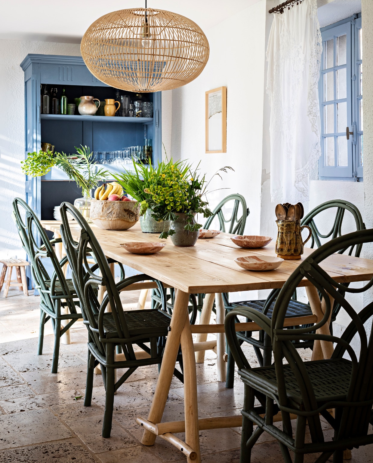 Hanglamp van markt in Marrakech, eettafel eigen ontwerp, eetkamerstoelen Marché de M, servies antiek, bloempotten rommelmarkt. Vergelijkbare blauwe verf kozijnen Borrowed Light en kast Kittiwake van Farrow &amp; Ball. Overig onbekend. vtwonen 07-2023 | fotografie Yann Deret