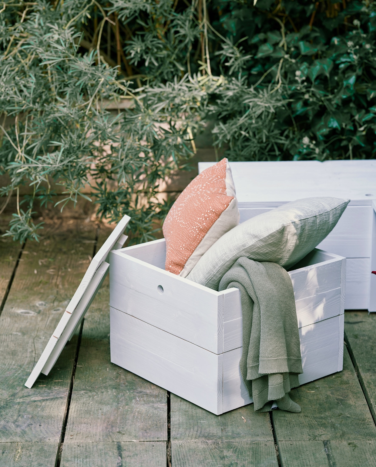 Zeegroen kussen, gebreide plaid (loods5.nl). Terra kussen met dessin (karwei.nl). vtwonen special tuin 06 | productie Corrien Flohil | styling Moniek Visser | uitvoering Johan Snoodijk | fotografie Sven Benjamins