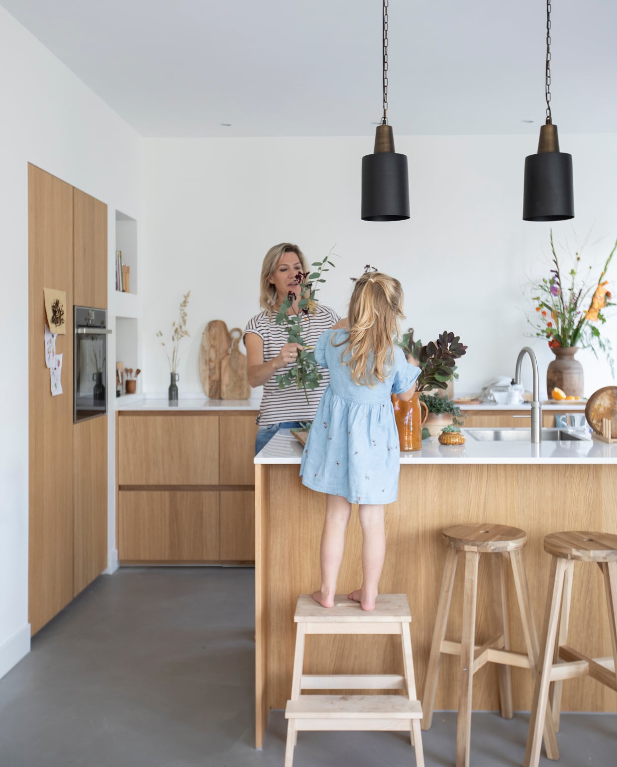 Massief houten keuken met composiet blad van Keukenontwerpers Woerden. Kraan Quooker. Lampen Light &amp; Living. Krukken en opstapkruk Ikea. Snijplanken Ikea, Sissy- Boy Homeland en Zara Home. Houten ontbijtborden H&amp;M Home. Vaas van een brocantemarkt. De vloer is een gietvloer. vtwonen 08-2021 | fotografie Macha Gutlich