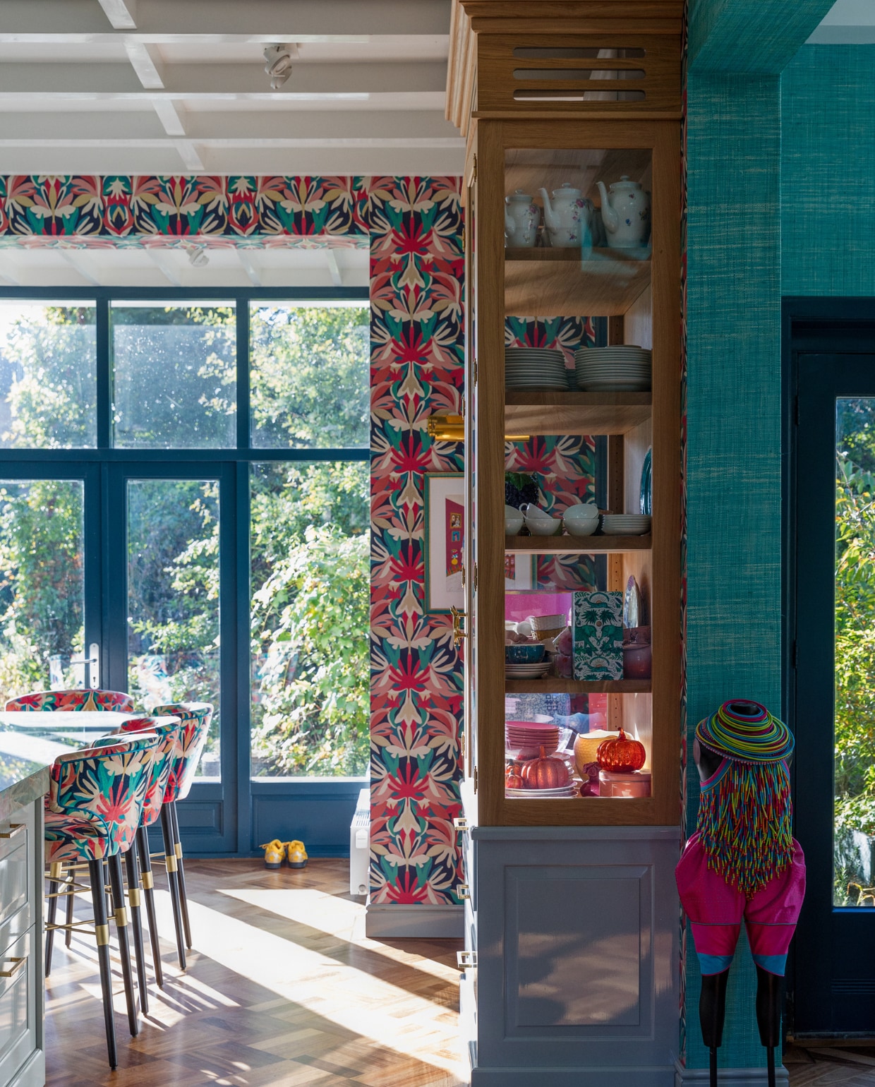 Behang print Harlequin, aquablauw behang Thibaut. Ontwerp barstoelen, keuken en kast Eef Langeler Design, houtverf kozijnen Hague Blue van Farrow &amp; Ball, kunstwerk van Rien Bekkers via Anna Singer Art. Overig onbekend. vtwonen 02-2023 | styling Ilona Jongepier | fotografie Dana van Leeuwen