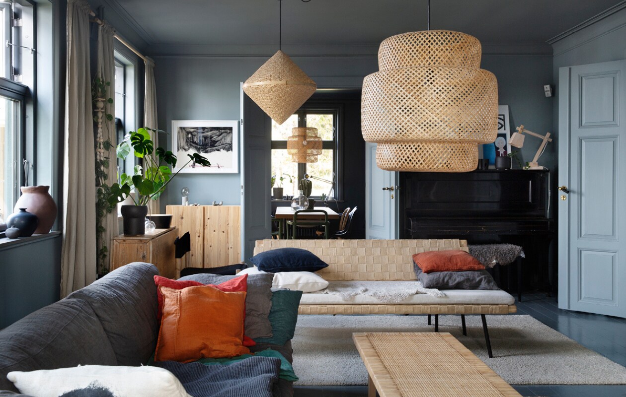 In de woonkamer een grijze bank van het Zweedse merk Melimeli, schommelstoel, kleed, bankje, salontafel en lampen van Ikea. vtwonen 07-2019 | fotografie Malin