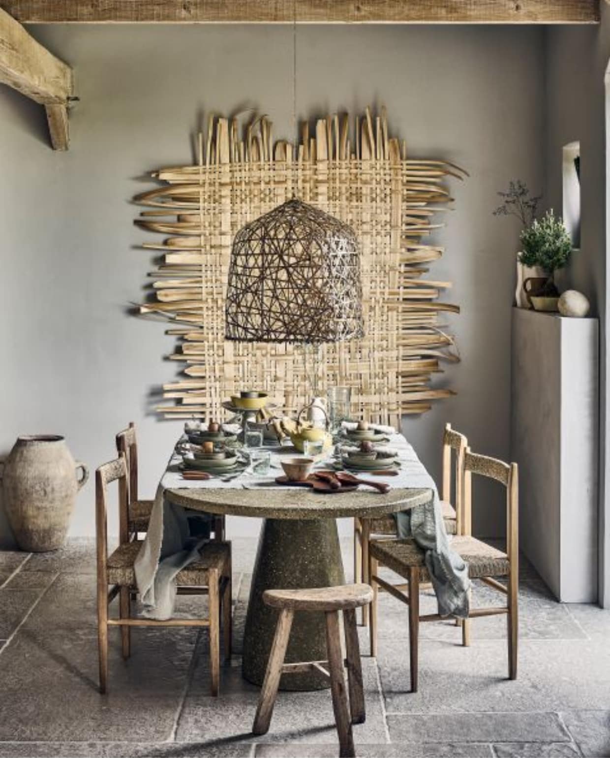 Wanddecoratie van La Nena, 117x142 cm € 1905,- (hetarsenaal.nl). Bamboe lampenkap Black Bird’s nest, 57x58 cm (Øxh) € 610,-, houten melkkruk € 155,-, terracotta kruik Berber nr. 61 € 595,-, mangohouten kom met handvat € 21,-, keramieken taartplateau € 159,-, geel servet € 13,- (couleurlocale.eu). Essenhouten stoel, 43x43x82 cm (bxdxh) € 179,- (zarahome.com). Stenen tafel, 204x100 cm (lxh) € 2400,- (lanena-home.com). Gewassen linnen tafelkleed, 140x240 cm € 49,99, houten servetringen, set van 2 € 7,99, witte kan, prijs op aanvraag (hm.com). Ecomix object Calcolo, set van 2 € 84,95 (urbannatureculture.com). Bonsai Pinus € 20,85 (plantje.nl). Witte aardewerken vaas Moire van Ferm Living € 139,-, essenhouten snijplank Cairn van Ferm Living, set van 3 € 139,-, essenhouten saladebestek Os van Ferm Living € 55,-, waterglazen van Serax, set van 4 € 58,-, serviesset Surface van Serax, 12-delig € 294,-, glazen karaf Pure van Serax € 39,-, diep bord Surface van Serax, set van 4 € 106,-, beige linnen servetten Pals van Kave Home € 26,98 (vtwonen.nl/shop). Olijfgroene keramieken theepot € 59,-, olijfgroene keramieken schaal € 149,- (sukha.nl). Houten bestek van Serax € 9,- (debijenkorf.nl). Overig privébezit. vtwonen 2023-09 | Styling Liza Wassenaar, assistentie Lila Steijger, Judith Koers, Kula Isabelle Den Broek | Fotografie Sjoerd Eickmans
