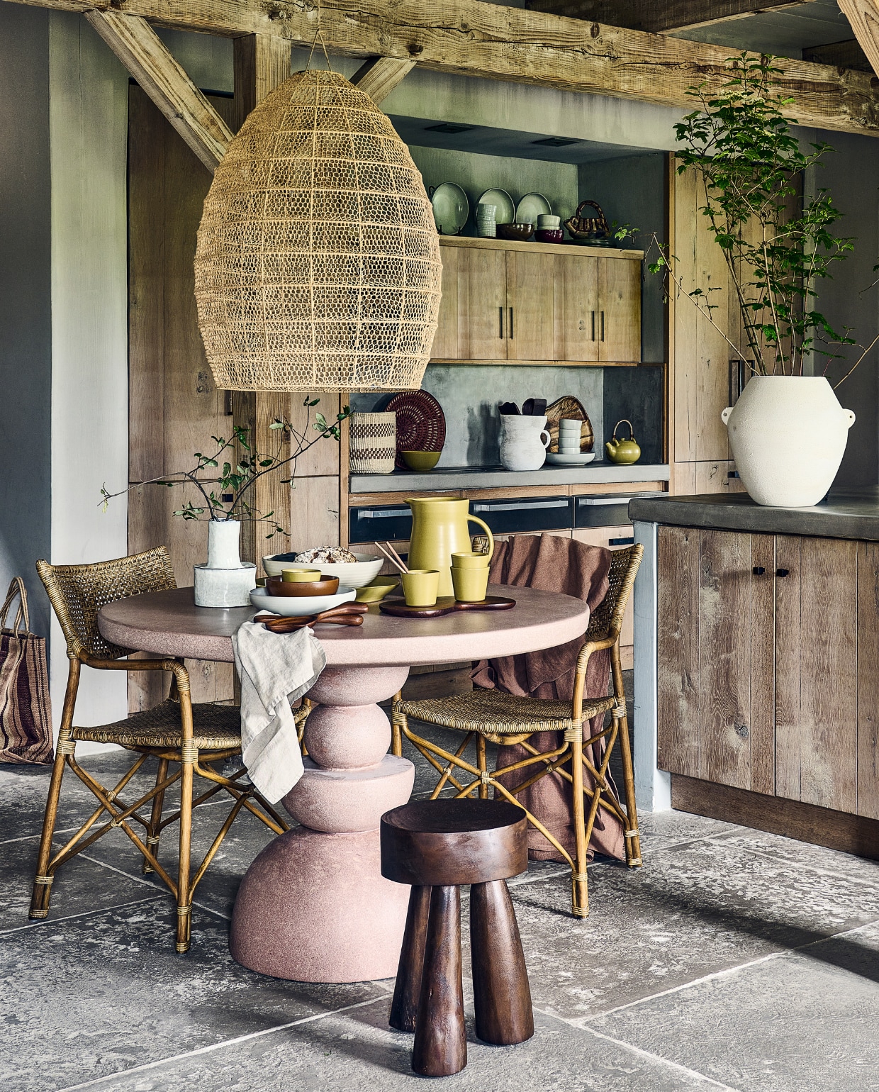 Roze cementen tafel Gijon € 1999,- (lanena-home.com). Macramé hanglamp, raffia met metalen structuur, 50x70 cm (Øxh) € 395,-, rotan stoel Sabany, 55x55x85 cm (bxdxh) € 475,-, jute tas Mati Jumbo € 85,-, sisal mand uit Kenia € 47,-, mand Kavango uit Namibië € 79,- (couleurlocale.eu). Houten bijzettafel Marco, 32x42 cm (Øxh) € 249,-, witte keramieken vaas op aanrecht Relaxed € 59,95, witte aardewerken vaas op kookeiland Sava € 169,- (urbannatureculture.com). Witte aardewerken vaas op tafel Héléna van Serax € 39,-, essenhouten saladebestek Os van Ferm Living € 55,-, porseleinen kommen Midi van Ferm Living, set van 3 € 79,- (vtwonen.nl/shop). Linnen tafelkleed van Himla, 250x145 cm € 129,- (debijenkorf.nl). Off-white geglazuurde stenen koppen Serena € 29,- (fermliving.com). Olijfgroene keramieken theepot € 59,-, olijfgroene keramieken kan € 139,-, olijfgroene theekoppen € 17,-, olijfgroene keramieken soepkom € 26,-, keramieken pastaborden Pebble € 34,- keramische theekop Pebble € 17,- (sukha.nl). Kan op kast (kringloopcentrumbollenstreek.nl). Snijplank € 29,99, beige servetset, set van 2 € 12,99 (hm.com). Overig privébezit. vtwonen 2023-09 | Styling Liza Wassenaar, assistentie Lila Steijger, Judith Koers, Kula Isabelle Den Broek | Fotografie Sjoerd Eickmans