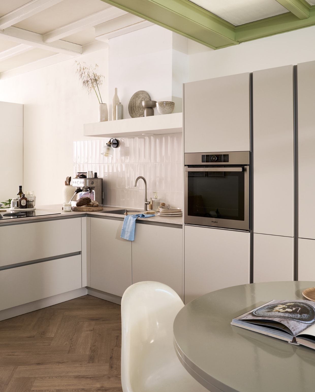 Keuken Basic Greige, hier in hoekopstelling, maar op diverse manieren samen te stellen, prijs op aanvraag. Wandtegels Shapes in Vapor van vtwonen, 7,5x30 cm, per m² € 59,-. M.m.v. vtwonen.nl/shop (tafel Deck van vtwonen), neeflouis.nl (stoel), bolia.com (karaf), hm.com (servies, marmeren plateau, schaal op voet, kan). Overig privébezit. vtwonen 09-2023 | productie Tanja Saarberg | styling Cleo Scheulderman | fotografie Jeroen van der Spek