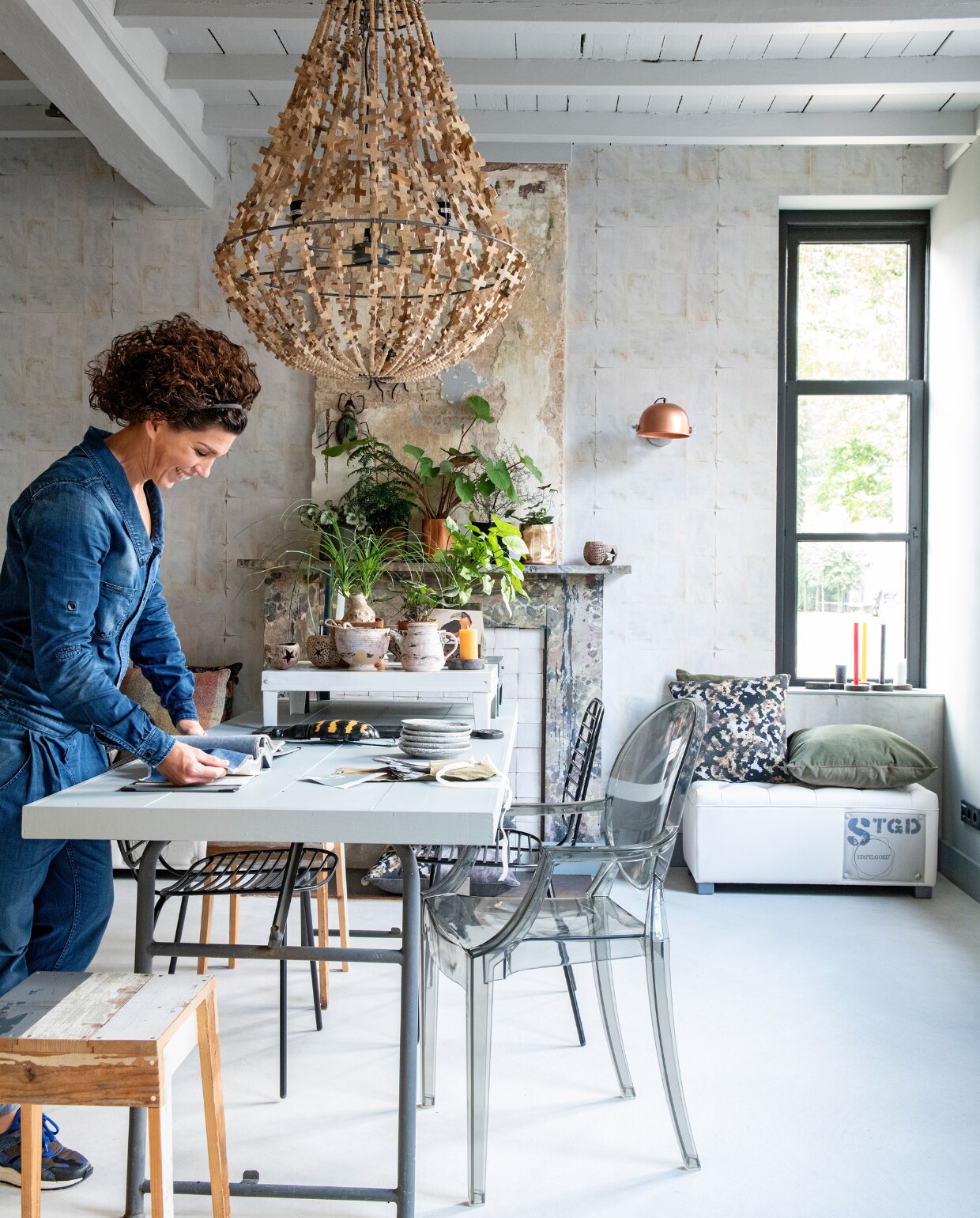 Het atelier en kantoor van woonlabel Stapelgoed bevinden zich aan de voorkant van de gerenoveerde boerderij. Cindy en Alex werken er aan de uitbreiding van hun collectie meubels, woonaccessoires, textiel en een eigen verf- en behanglijn. De houten lamp Cross van Stapelgoed is niet meer leverbaar. Tafel Combitex, sloophouten krukje Piet Hein Eek, Ghost Chair van Philippe Starck voor Kartell en behang Storyworld Stapelgoed. vtwonen 11-2019 | styling Esther Loonstijn | fotografie Louis Lemaire