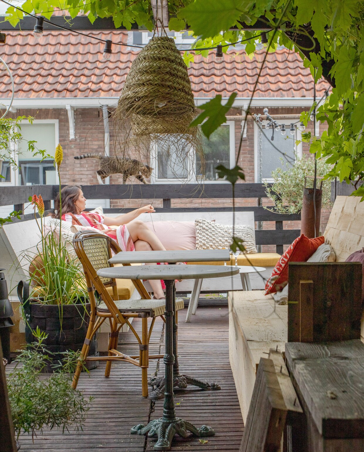 Bistrotafels en stoel vintage, rotan lamp Noa May Living, lichtsnoer en zwarte plantenbak Sissy-Boy, banken op maat laten maken, kussens op bank v.l.n.r. H&amp;M Home, Natural Lifestyle, Leen Bakker. vtwonen 08-2022 | productie en fotografie Anne den Haan | styling Luka Jakobs