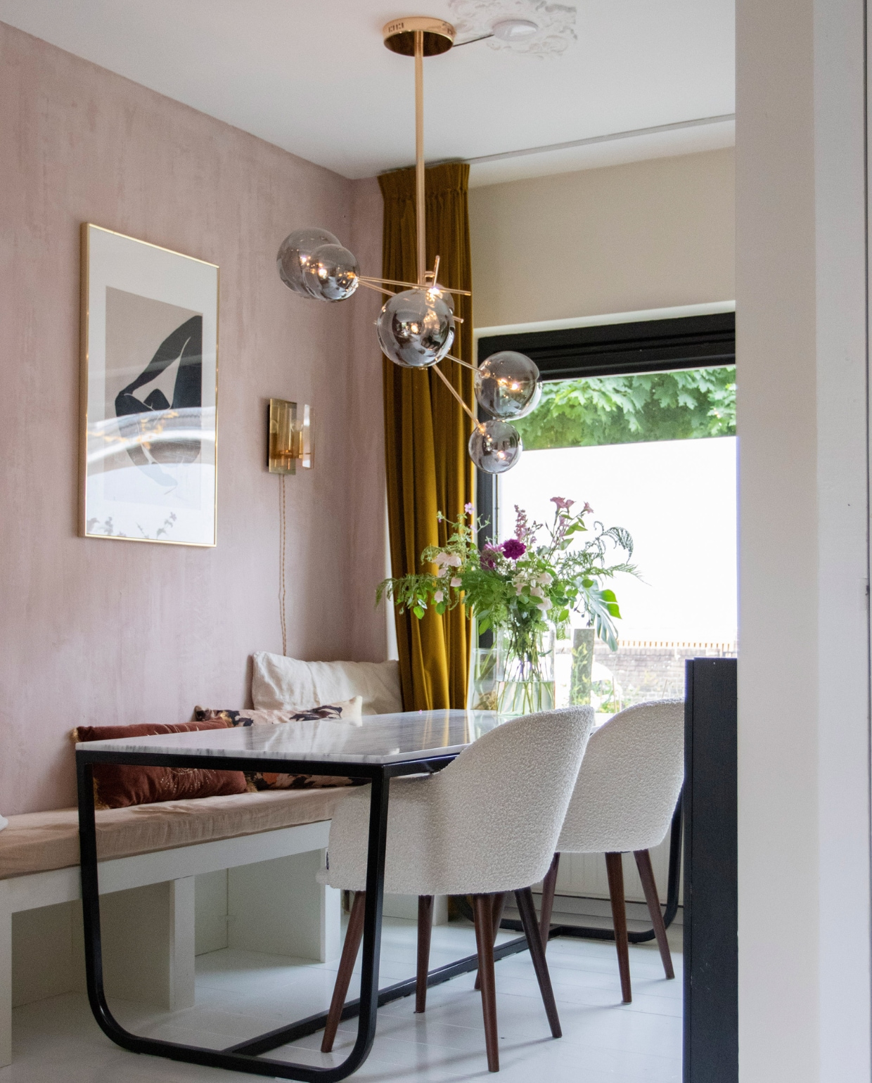 Kalkverf Skin Powder van Pure &amp; Original, gordijnen Hema, eettafel Furnified, eetkamerstoelen Sofa Company, lamp boven tafel Fonq, lamp en lijst aan de muur vintage, karaf op tafel H&amp;M Home, kunstwerk en bank zelfgemaakt. Kussens op bank v.l.n.r. Sissy-Boy, HKliving, H&amp;M Home. Overig onbekend. vtwonen 08-2022 | productie en fotografie Anne den Haan | styling Luka Jakobs