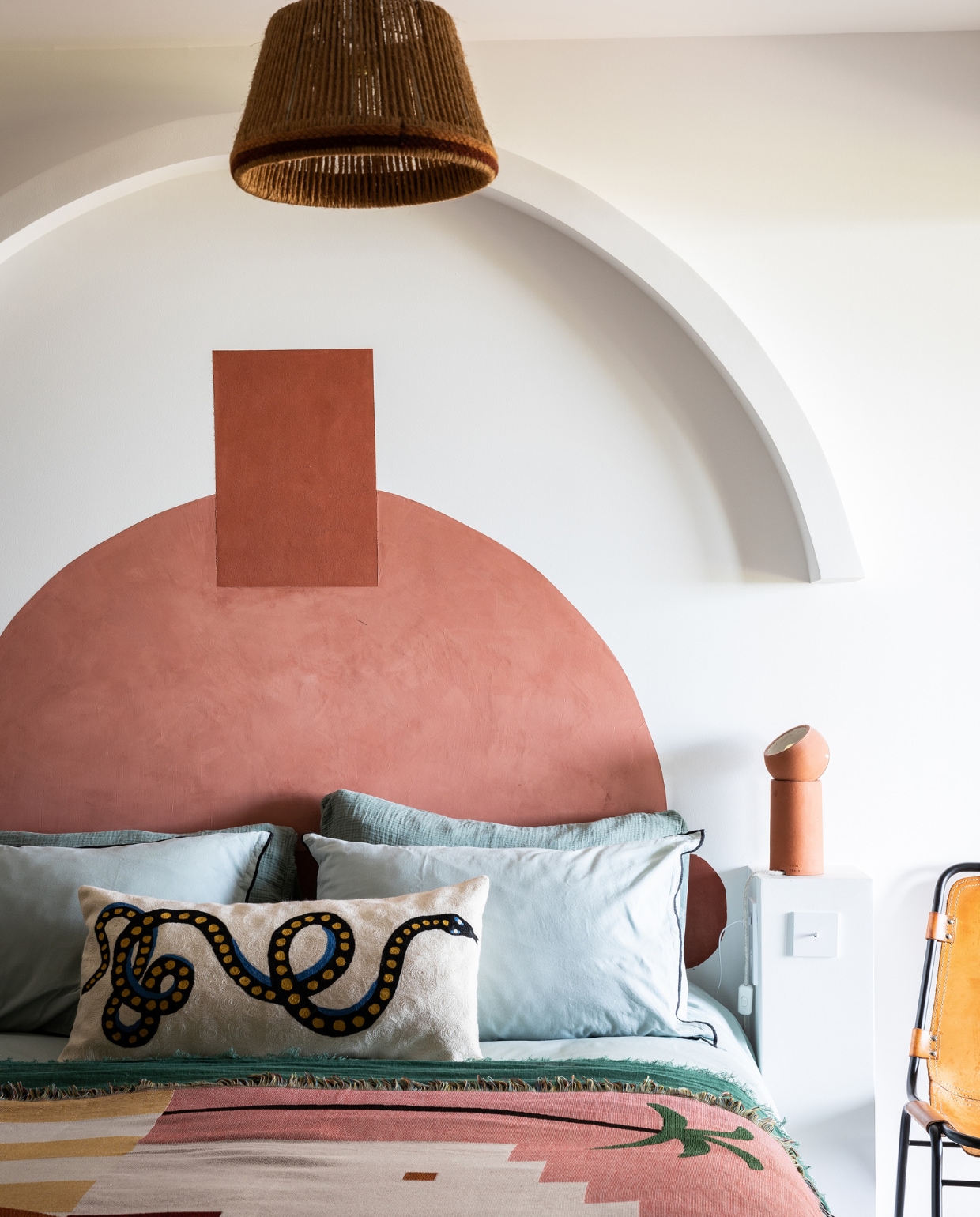 Bedsprei uit Mexico. Kussen slang Avdw Antwerp. Stoel Charlotte Perriand. Bedlamp Serax. Rotan hanglamp vintage. Beddengoed en verf onbekend. vtwonen 07-2023 | productie &amp; styling Marie Maud Levron | fotografie Yann Deret