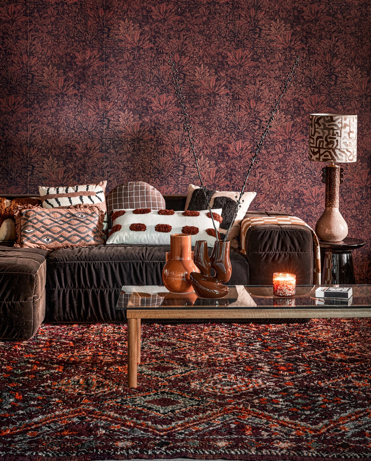 Vliesbehang Sauvage Burgundy, 53x100,5 cm (bxl), per rol _ 125,- (masureel.com). Polyester bank Brut in Espresso, 308x105x71 cm (bxdxh) _ 3290,- (hkliving.com). Wollen vloerkleed Beni Mguild 31380, 396x213 cm _ 1190,- (rozenkelim.nl). Salontafel Kofi, hout en glas _ 689,- (hay.dk). Tafellamp, keramiek en linnen _ 525,- (madamgarage.nl). Katoenen kussen Galia van Bloomingville _ 59,90, katoenen kussen Africa van vtwonen _ 39,95, rond katoenen kussen Kyoto van Oyoy _ 54,99, katoenen kussen met grof geborduurde steek van vtwonen _ 49,95, kussen Lay van Ferm Living, katoen en wol _ 79,-, keramieken bijzettafel Earthenware van HKliving _ 279,-, aardewerken vaas Ceramic van HKliving _ 49,95, keramieken vaas Organic van HKliving _ 59,95 (vtwonen.nl/shop). Overig privébezit. styling Kelly van Gendt | fotografie Peggy Janssen