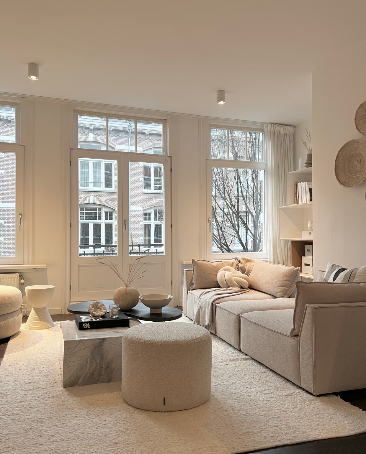 Modulebank Daphne, fauteuil Alma, poef en vloerkleed van Sofacompany. Knoopkussen H&amp;M home. Salontafels maatwerk van Onno Design. Kruk van Philip Starck, zelf geschilderd. Vaas op salontafel Urban Nature Culture. Overig onbekend. Klaas Hogeweg