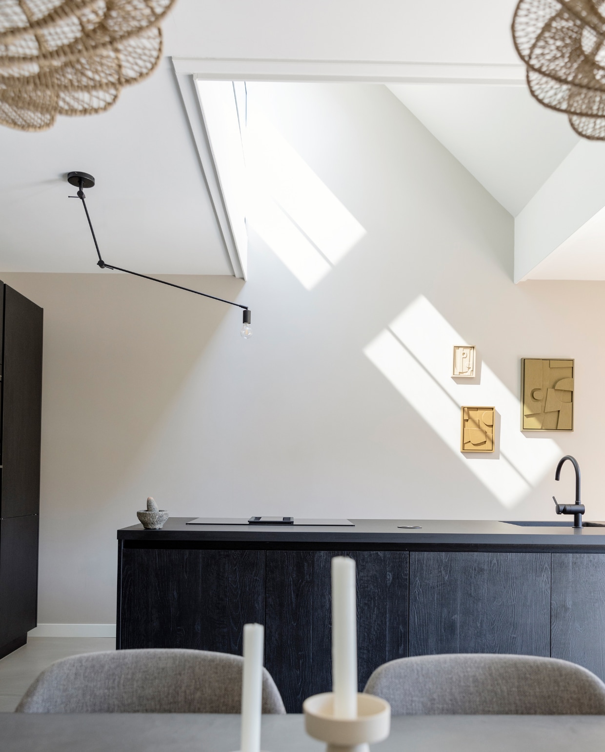 Keuken met Fenix keukenblad en spoelbak Huysinc. Kookplaat Siemens, hanglampen Blitz van Qazqa, kunstwerken 3D Shapes van Edith Beurskens, muurverf Mushroom van Lab Paint, hanglamp Nimbus van By-Boo, stoelen Konna van Kave Home, kandelaars Storefactory Scandinavia. vtwonen | styling Ilona Jongepier | fotografie Dana van Leeuwen