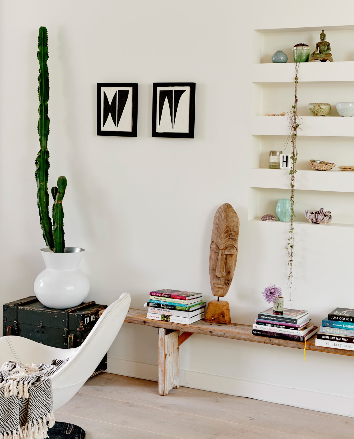 Legerkist en steigerhouten bankje van Ivonne Old Furniture Antwerpen. Schilderijen van Art in Return. Houten beeld was een cadeau. vtwonen 04-2020 | productie Features &amp; More | styling Wilma Custers | fotografie Renee Frinking