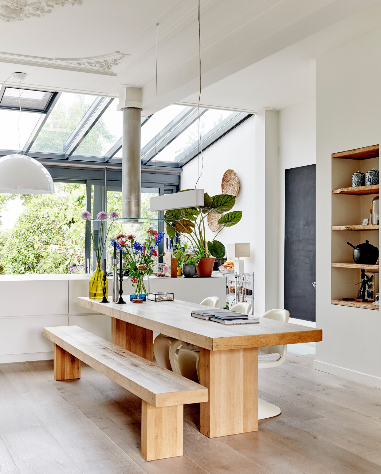 De eettafel en bank zijn een eigen ontwerp, ge_nspireerd op een ontwerp van Piet Boon en uitgevoerd door eikentafels.nl. Lamp Skygarden van Flos ontworpen door Marcel Wanders. Stoelen aan eettafel Vitra Panton._ vtwonen 04-2020 | productie Features &amp; More | styling Wilma Custers | fotografie Renee Frinking