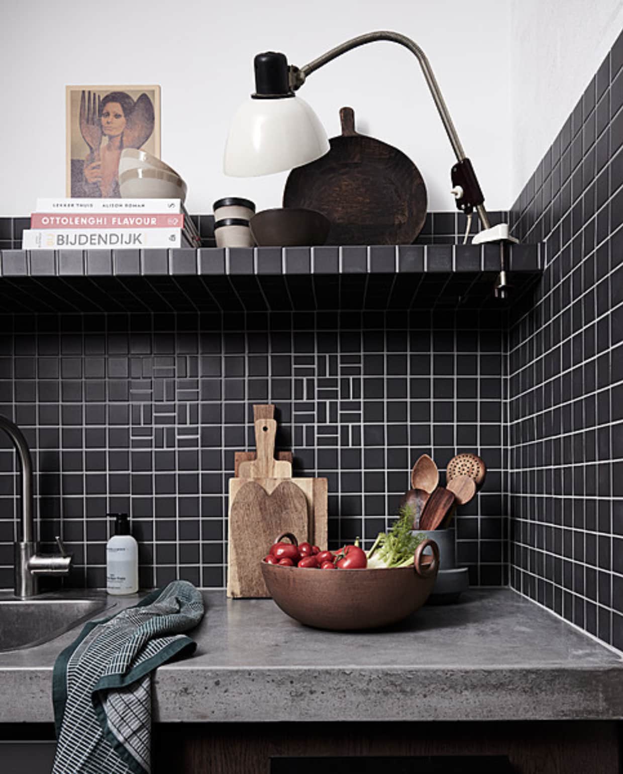 Matzwarte moza_ektegel, 30,5x30,5 cm, per mat _ 4,25 (hornbach.nl). Bekers en kommen Clay _ 7,50 (householdhardware.nl). Mangohouten serveerplank _ 79,95 (urbannatureculture.com). Vintage lamp _ 65,- (com-anders.nl). Houten schalen, bestek en planken, en overig priv_bezit. vtwonen 2023-10 | Styling Fietje Bruijn | Fotografie Alexander van Berge