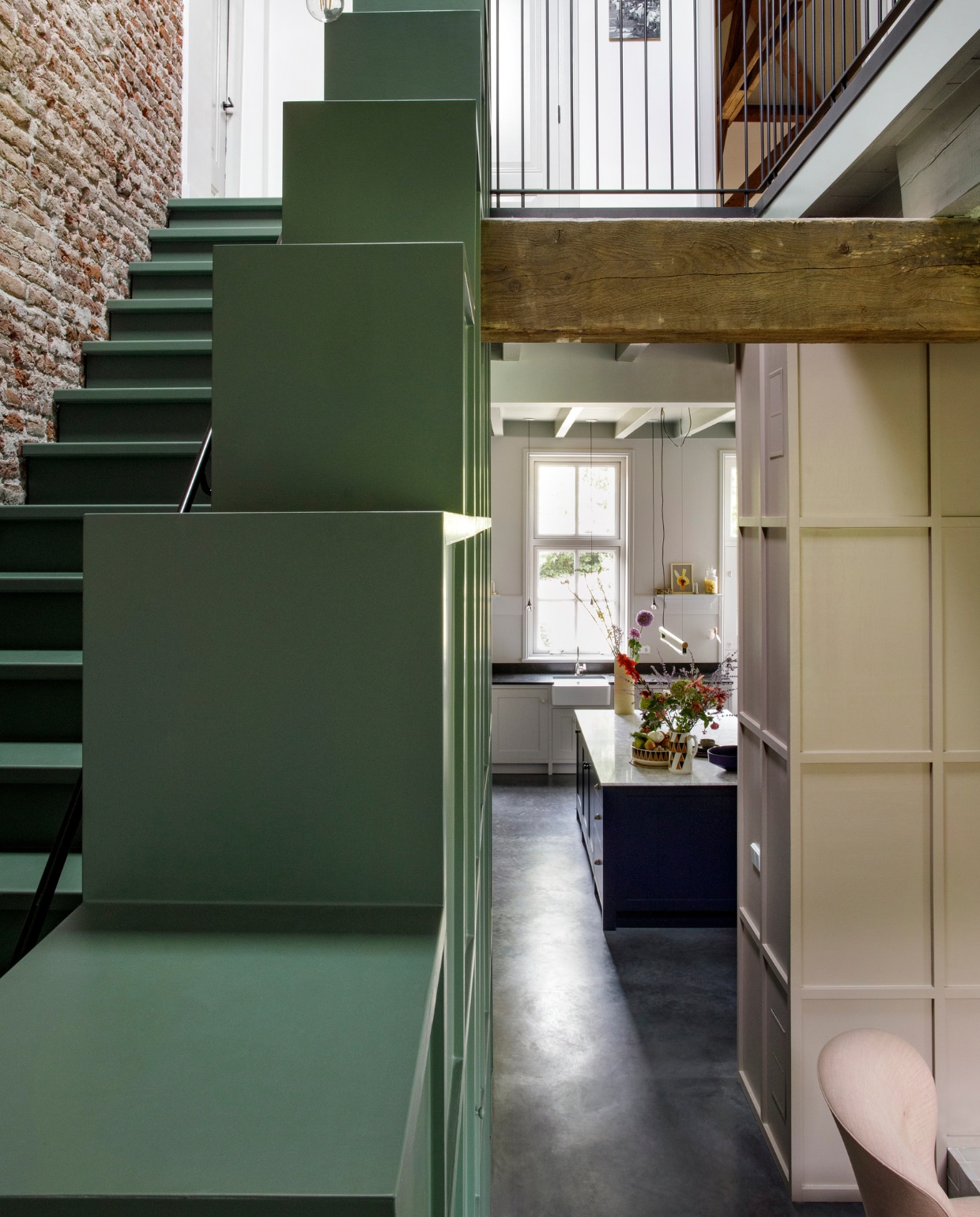 Trapkast, zwarte stalen balustrade en vlakverdeling op wand eigen ontwerp. Herkomst hanglamp onbekend. Schilderij uit Nigeria. Verf trap en kast Green Smoke van Farrow & Ball. vtwonen 10-2020 | fotografie Inga Powilleit | styling José Martens