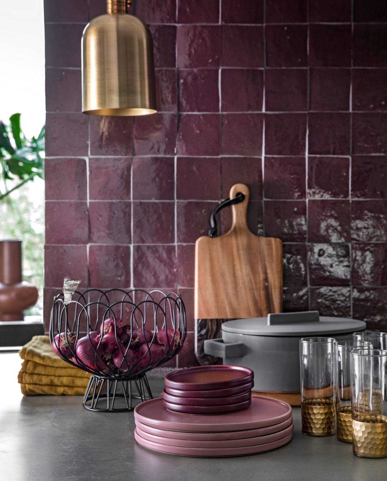 Auberginekleurige zelliges, 10x10 cm per m² € 94,50 (designtegels.nl). Bronskleurig hanglampje Aisha van Lifestyle € 69,95, draadschaal van Present Time € 17,49, grijze ovalen kookpan Terra Cotto van Eva Solo € 77,50, terraroze vaas Theseus van Urban Nature Culture € 59,95 (vtwonen.nl). Plank € 47,95, ovale plank (onder de pan) € 47,95, longdrink glazen Reflexions per stuk € 10,95 (zenzahome.com). Okergele theedoeken per stuk € 3,- (hema.nl). Oudroze dinerborden per stuk € 9,99, aubergine kleurige bordjes per stuk € 4,99 (hm.com). vtwonen 02-2019 | styling Moniek Visser | fotografie Peggy Janssen