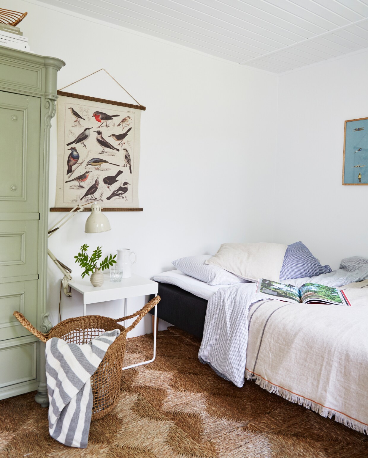 Kledingkast vintage. Bijzettafel als nachtkastje en geruit dekbedovertrek Ikea. Sprei H&amp;M Home. Vaasje en lamp rommelmarkt. Vloerkleed oThe Bauhaus. Poster vogelsoorten antiek. Overig onbekend. vtwonen special binnenkijken 06-2023 | productie Living Inside | fotografie Anitta Behrendt | styling Rikke Graff Juel