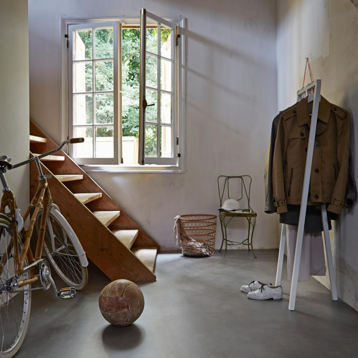Fiets, leren pet en schoenen, lange jas Restored, mand en kapstok Mobilia Woonstudio, stoel De Weldaad, kledinghangers Ikea, leren bal Neef Louis, overige jassen privébezit. styling Frans Uyterlinde | fotografie Alexander van Berge