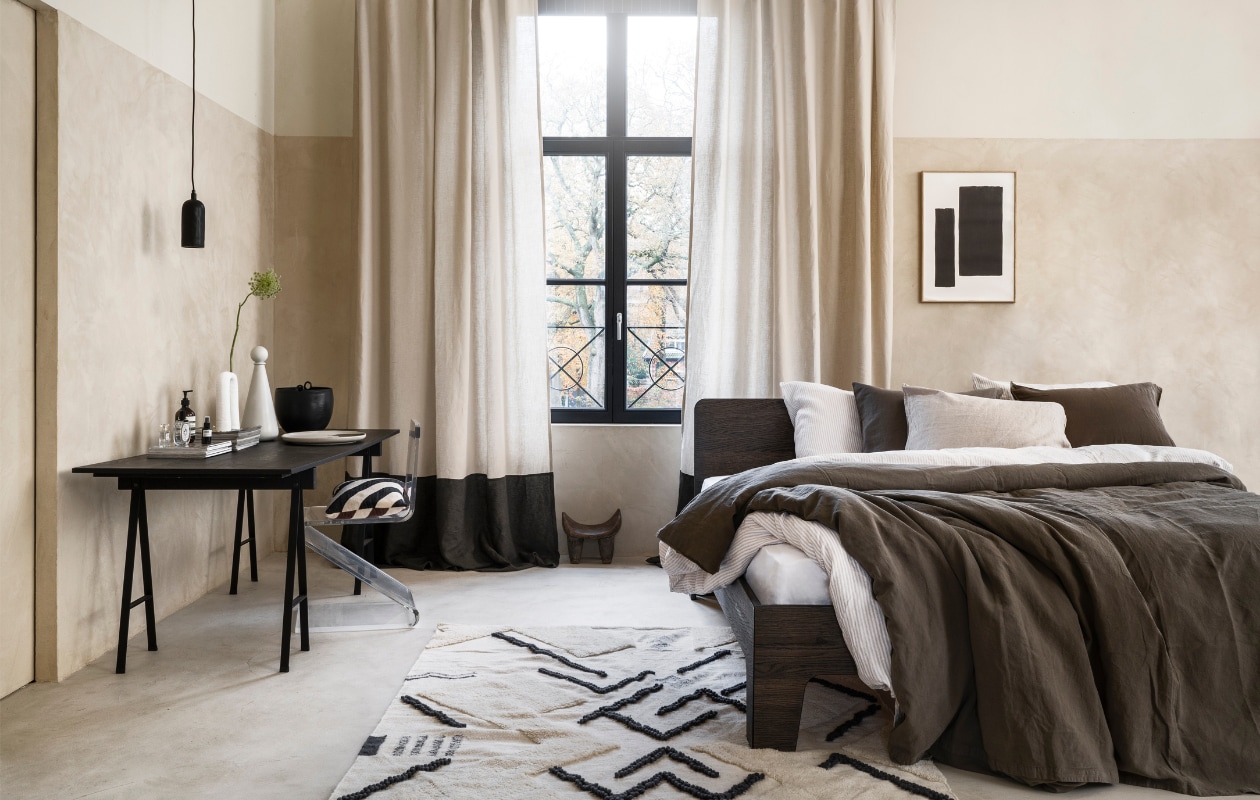 Stucco-look muurverf Mykonos, 2,5 liter € 110,- (wearewowmakers.com). Gordijn gemaakt van linnen Cloud Rider van Chivasso, per meter € 114,50 (jab.de). Bedombouw Pure, eiken fineer in Charcoal olie, 180x200 cm (bxd) € 3400,- (loof.nl). Duurzaam gewassen linnen dekbed-
overtrekset met smalle strepen, 240x220 cm € 329,- (yumeko.nl). Bruine dekbedovertrekset, duurzaam linnen en katoen, 240x220 cm € 179,95 (suite702.com). Vloerkleed, 260x160 cm € 399,- (malagoon.com). Tafel van Serax, 150x75x73cm (lxbxh) € 824,-, vaas met bolvormig deksel van Ferm Living € 85,-, schaal Omhu van Ferm Living € 105,- (flinders.nl). Vintage transparante zigzagstoel € 350,- (neeflouis.nl). Hanglamp € 79,95, pot met oor € 62,95 (urbannatureculture.com). Vaas met twee poten van vtwonen € 49,95, gestreept kussen van Oyoy € 54,99 (vtwonen.nl). Poster met lijst vanaf € 95,- (loods5.nl). Afrikaans krukje privébezit. vtwonen 03-2023 | styling Marianne Luning | fotografie Stan Koolen